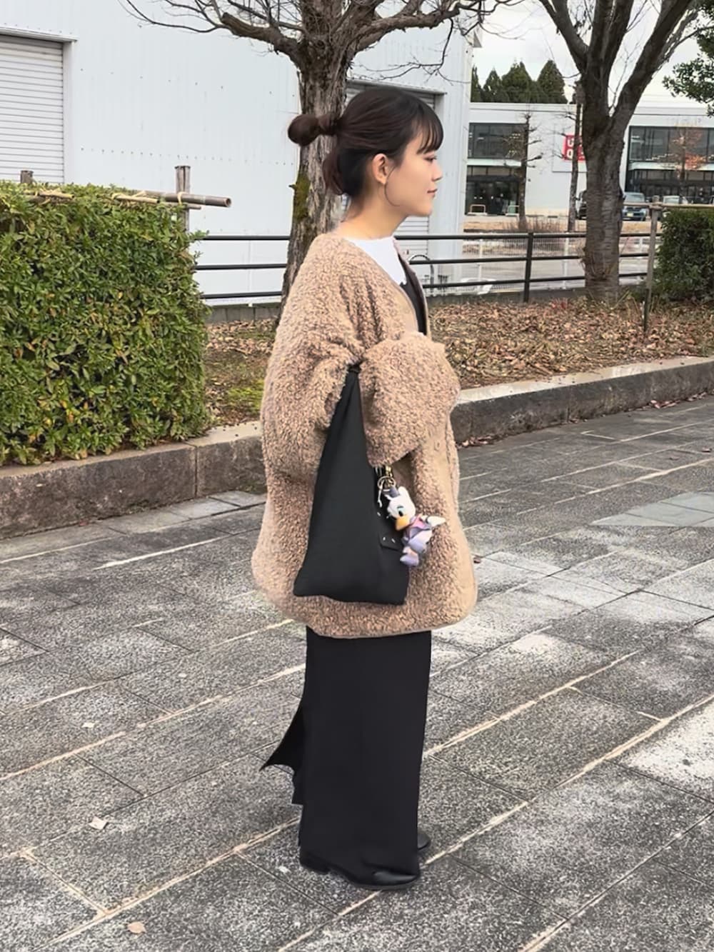 ブラック系のワンピース、ベージュ系のブルゾン、ブラック系のブーツを着用したレディースの冬コーディネートの2枚目の写真