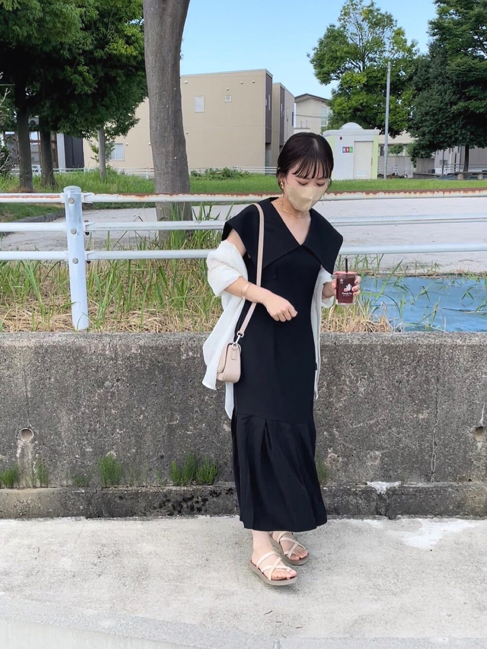 ブラック系のワンピース/ドレス、ベージュ系のショルダーバッグ、ホワイト系のシャツ/ブラウスを着用したレディースの夏コーディネートの2枚目の写真