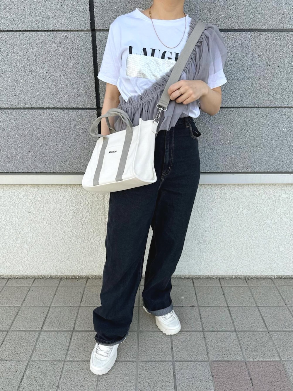 ホワイト系のトートバッグ、グレー系のその他トップス、ブラック系のデニムパンツを着用したレディースの春コーディネートの5枚目の写真