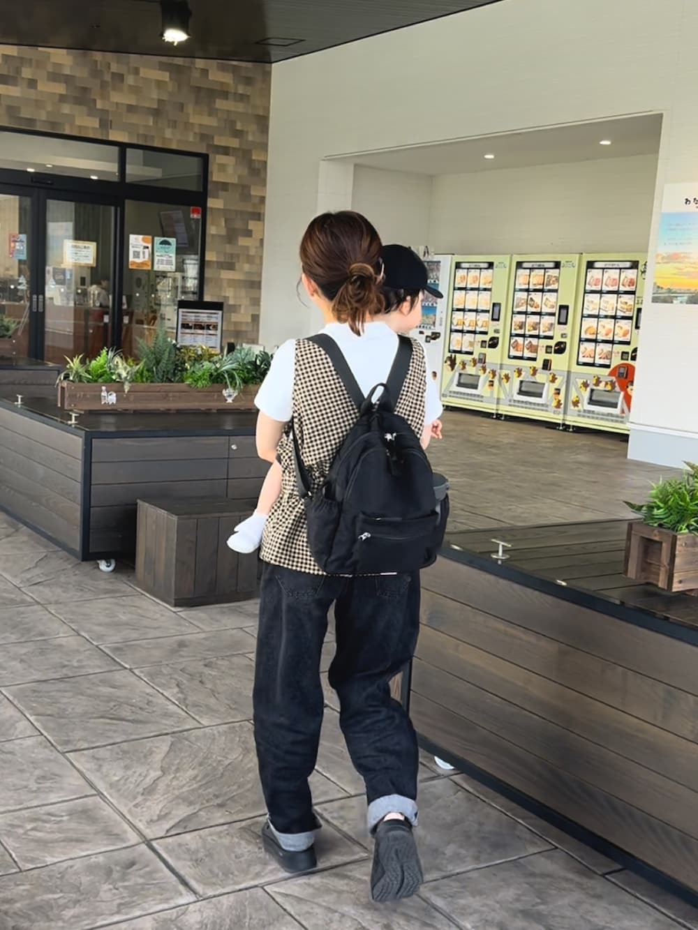 ブラック系のサンダル、ブラウン系のベスト、ブルー系のデニムパンツを着用したレディースの夏コーディネートの3枚目の写真