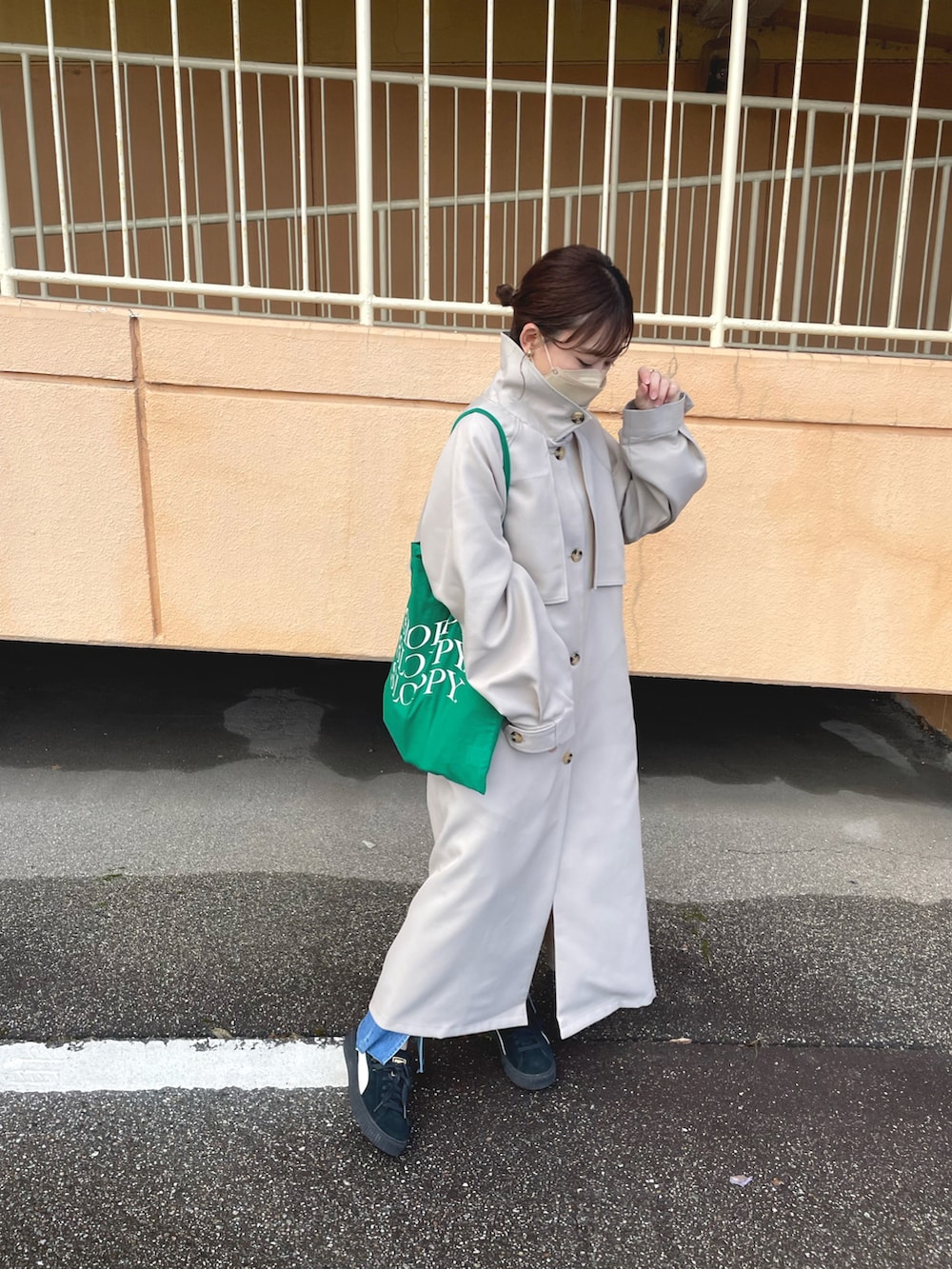 ベージュ系のトレンチコート、ホワイト系のTシャツ/カットソー、ブルー系のデニムパンツを着用したレディースの冬コーディネートの5枚目の写真