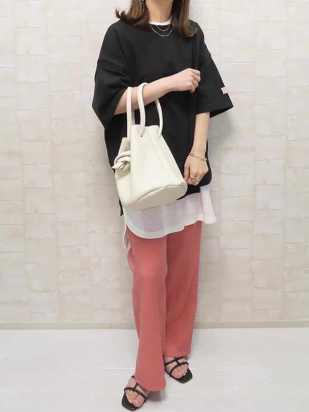 ブラック系のTシャツ/カットソー、ホワイト系のタンクトップ、ピンク系のスラックスを着用したレディースの春コーディネートの3枚目の写真