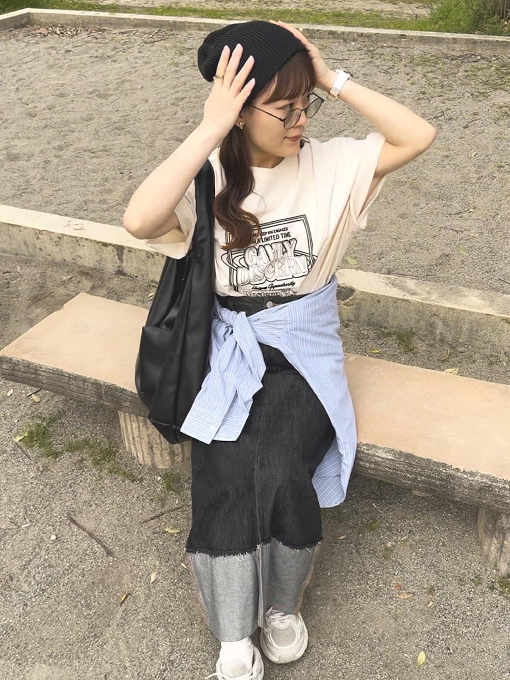 ホワイト系のTシャツ/カットソー、ベージュ系のスニーカー、ブラック系のデニムスカートを着用したレディースの夏コーディネートの2枚目の写真
