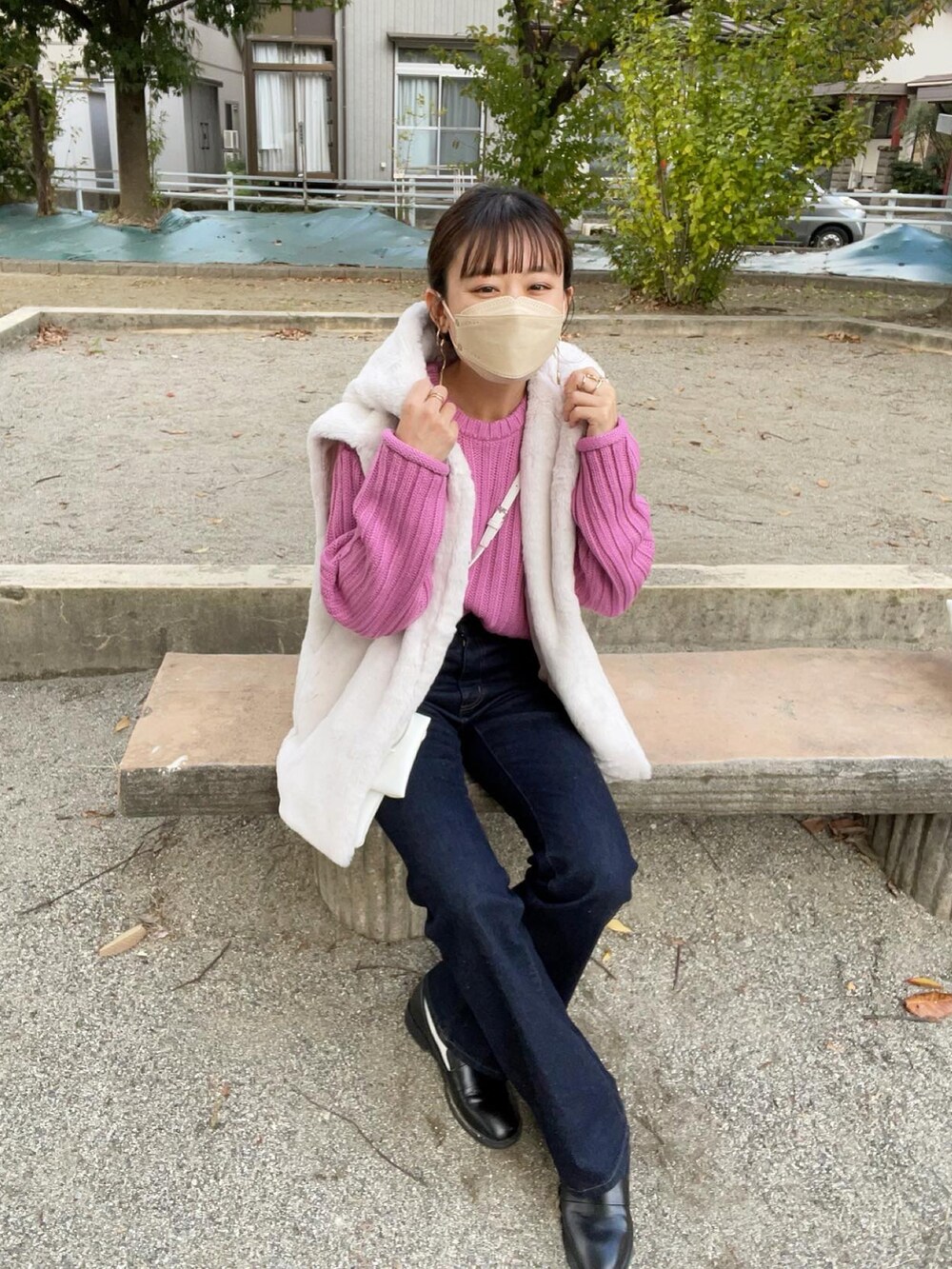 ピンク系のニット/セーター、ホワイト系のジャケット/アウター、ブルー系のデニムパンツを着用したレディースの秋コーディネートの2枚目の写真