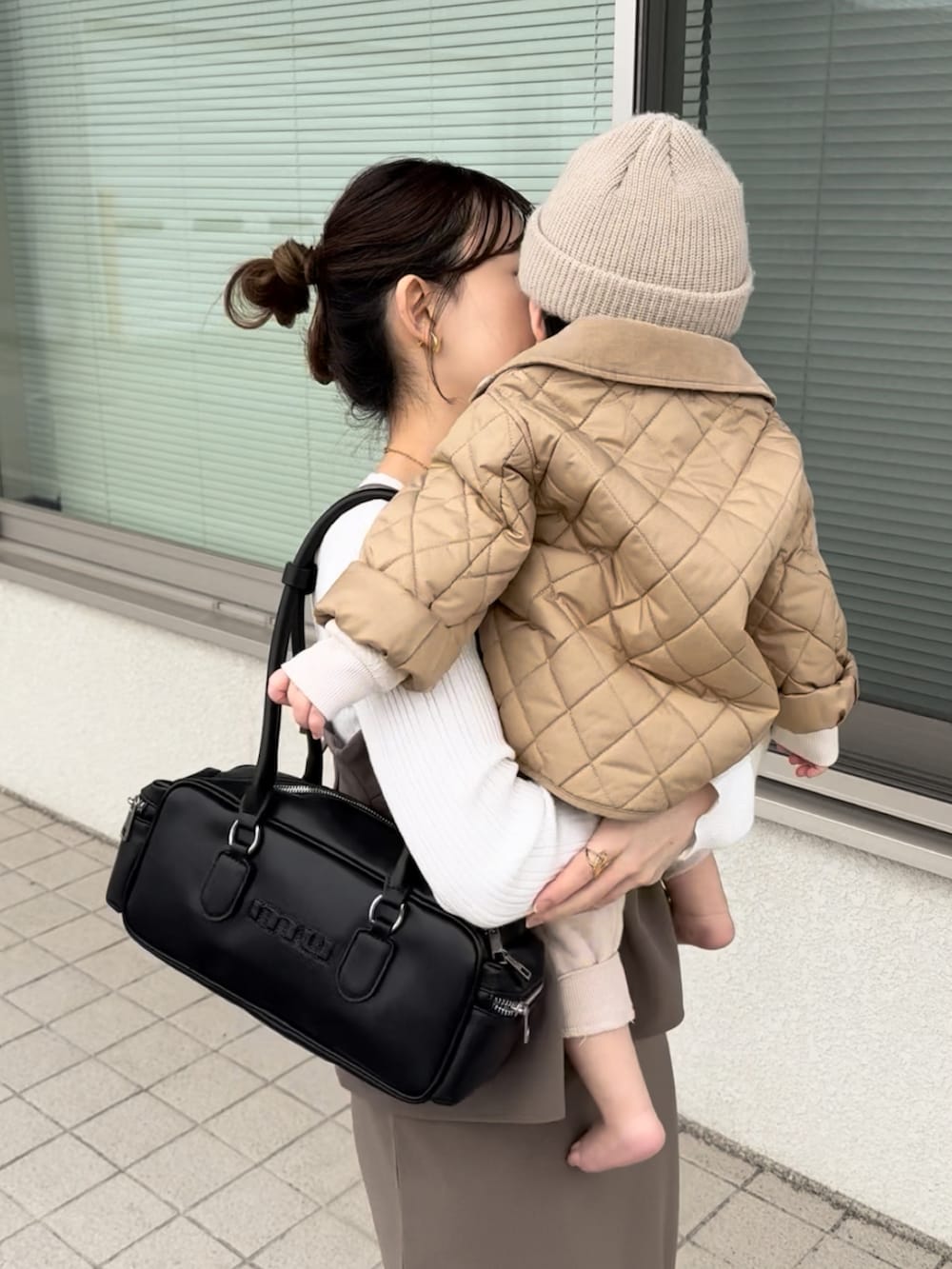 ブラウン系のワンピース、ブラック系のボストンバッグ、ブラック系のその他シューズを着用したレディースの春コーディネートの3枚目の写真