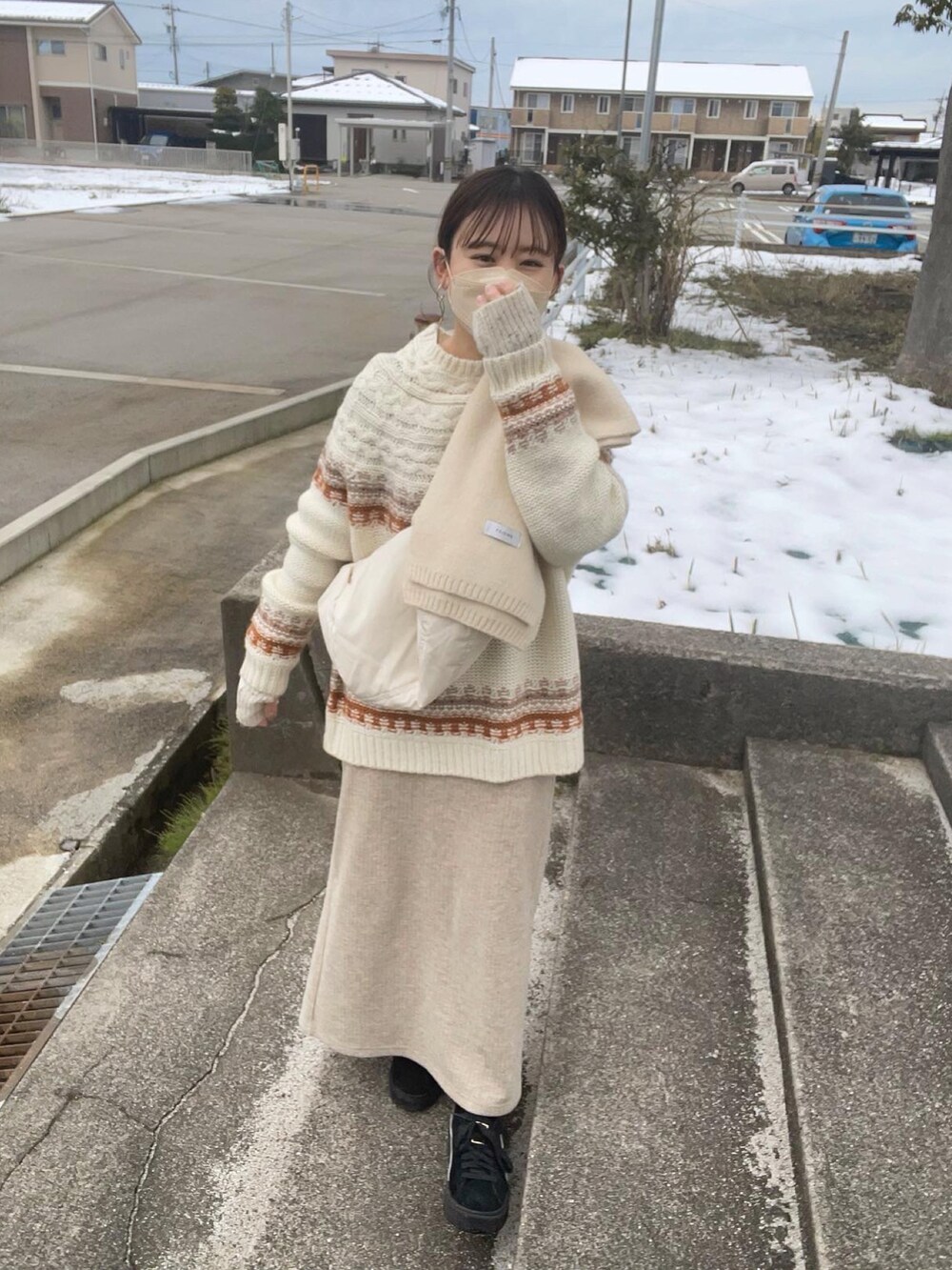 ブラウン系のニット/セーター、ホワイト系のショルダーバッグ、ベージュ系のスカートを着用したレディースの冬コーディネートの3枚目の写真