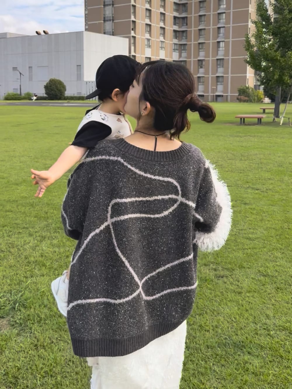 ブラウン系のカーディガン/ボレロ、ホワイト系のワンピース/ドレス、ブラック系のスニーカーを着用したレディースの秋コーディネートの2枚目の写真