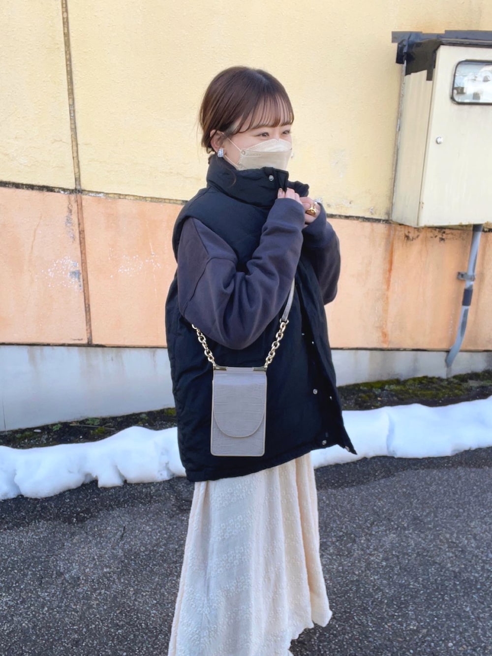 グレー系のスウェット、ホワイト系のTシャツ/カットソー、ベージュ系のスカートを着用したレディースの冬コーディネートの2枚目の写真