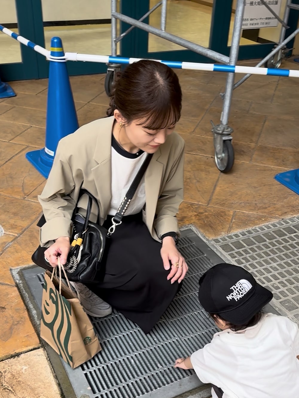 ベージュ系のジャケット/アウター、ホワイト系のTシャツ/カットソー、ブラック系のボストンバッグを着用したレディースの夏コーディネートの2枚目の写真