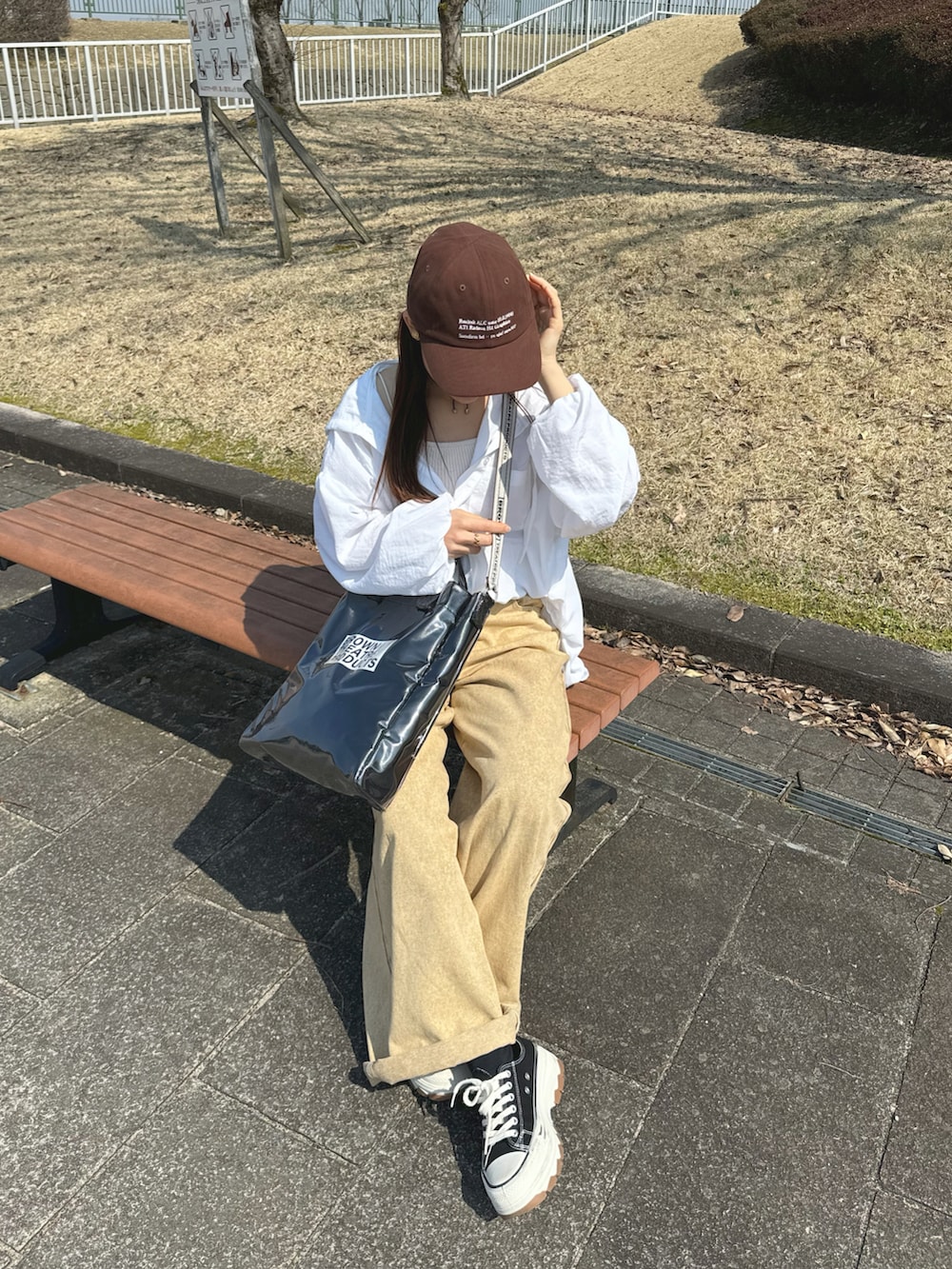 ホワイト系のシャツ/ブラウス、ブラック系のトートバッグ、ベージュ系のパンツを着用したレディースの春コーディネートの5枚目の写真