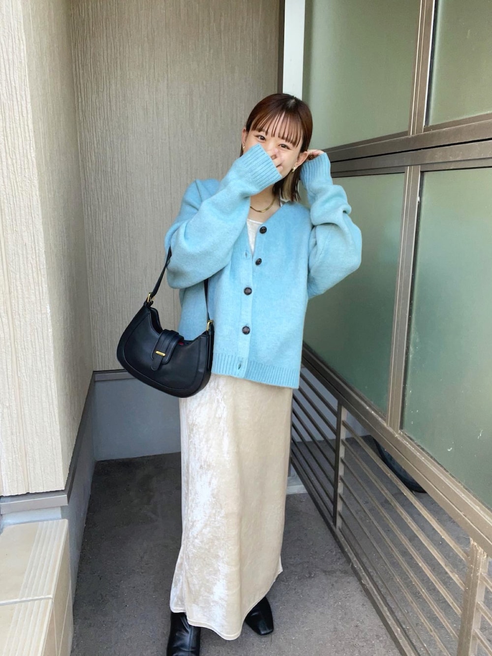 ブルー系のカーディガン/ボレロ、ホワイト系のワンピース、ブラック系のバッグを着用したレディースの秋コーディネートの2枚目の写真