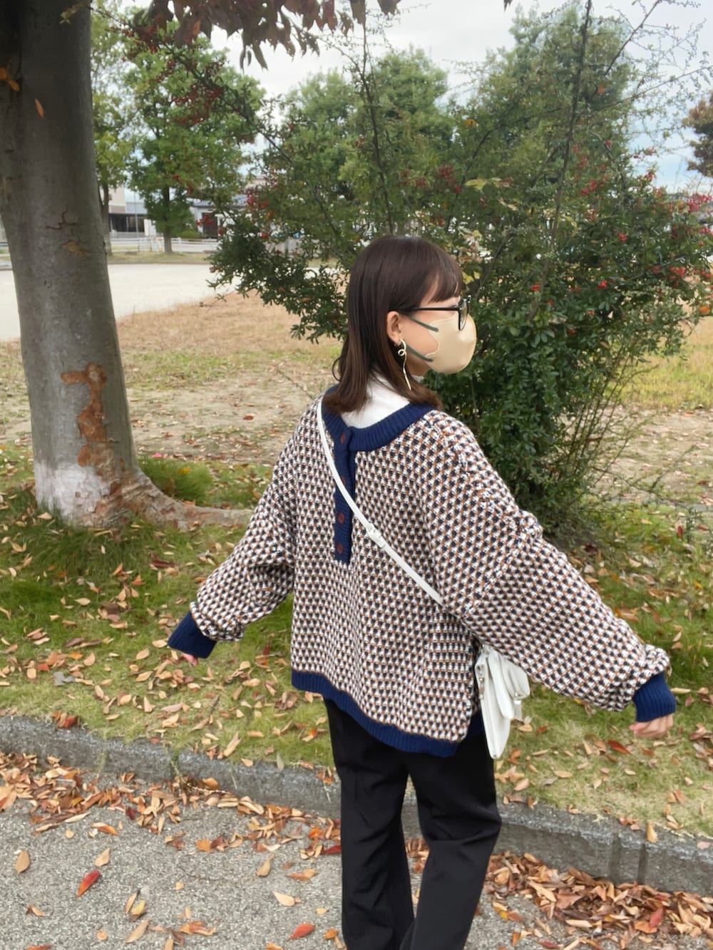 ブルー系のニット/セーター、ホワイト系のTシャツ/カットソー、ホワイト系のショルダーバッグを着用したレディースの秋コーディネートの2枚目の写真