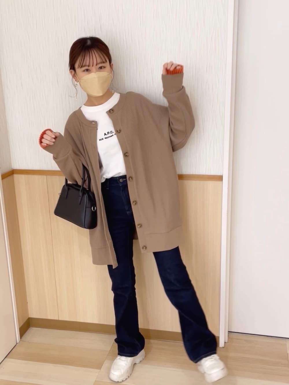 ブラウン系のカーディガン/ボレロ、ブルー系のデニムパンツ、ホワイト系のスニーカーを着用したレディースの春コーディネートの4枚目の写真