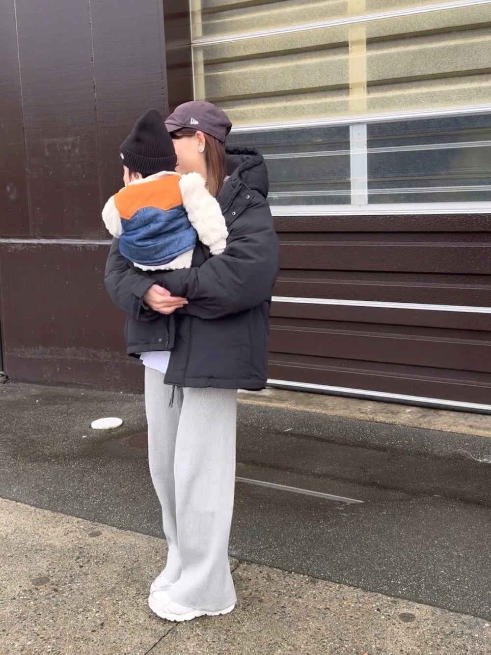 ブラック系のダウンジャケット/コート、グレー系のニット/セーター、グレー系のパンツを着用したレディースの冬コーディネートの4枚目の写真