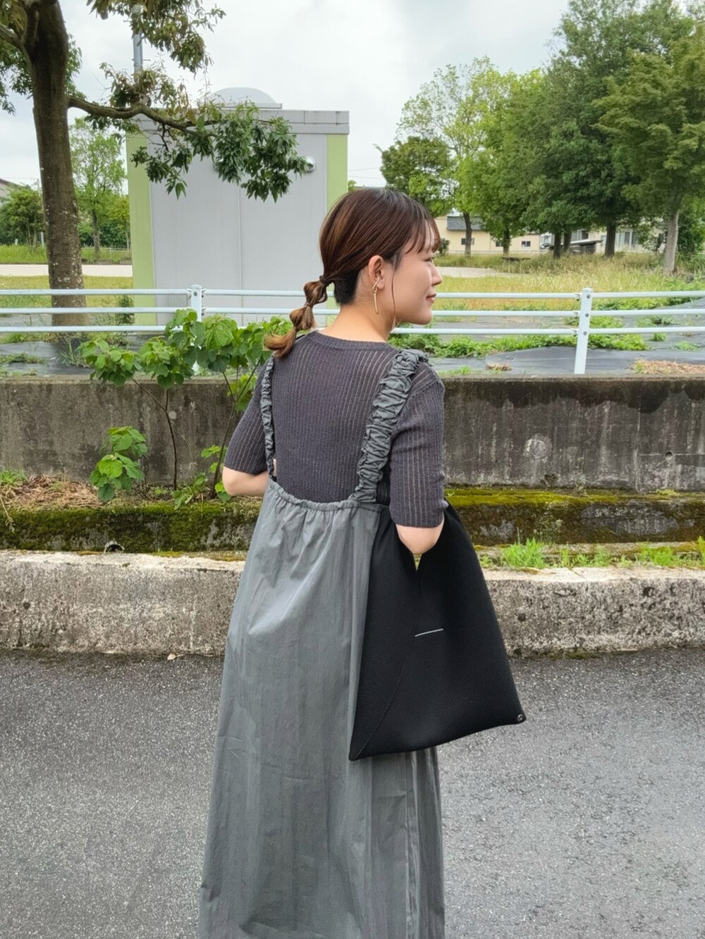 グレー系のワンピース、グレー系のトップス、ブラック系のトートバッグを着用したレディースの夏コーディネートの4枚目の写真