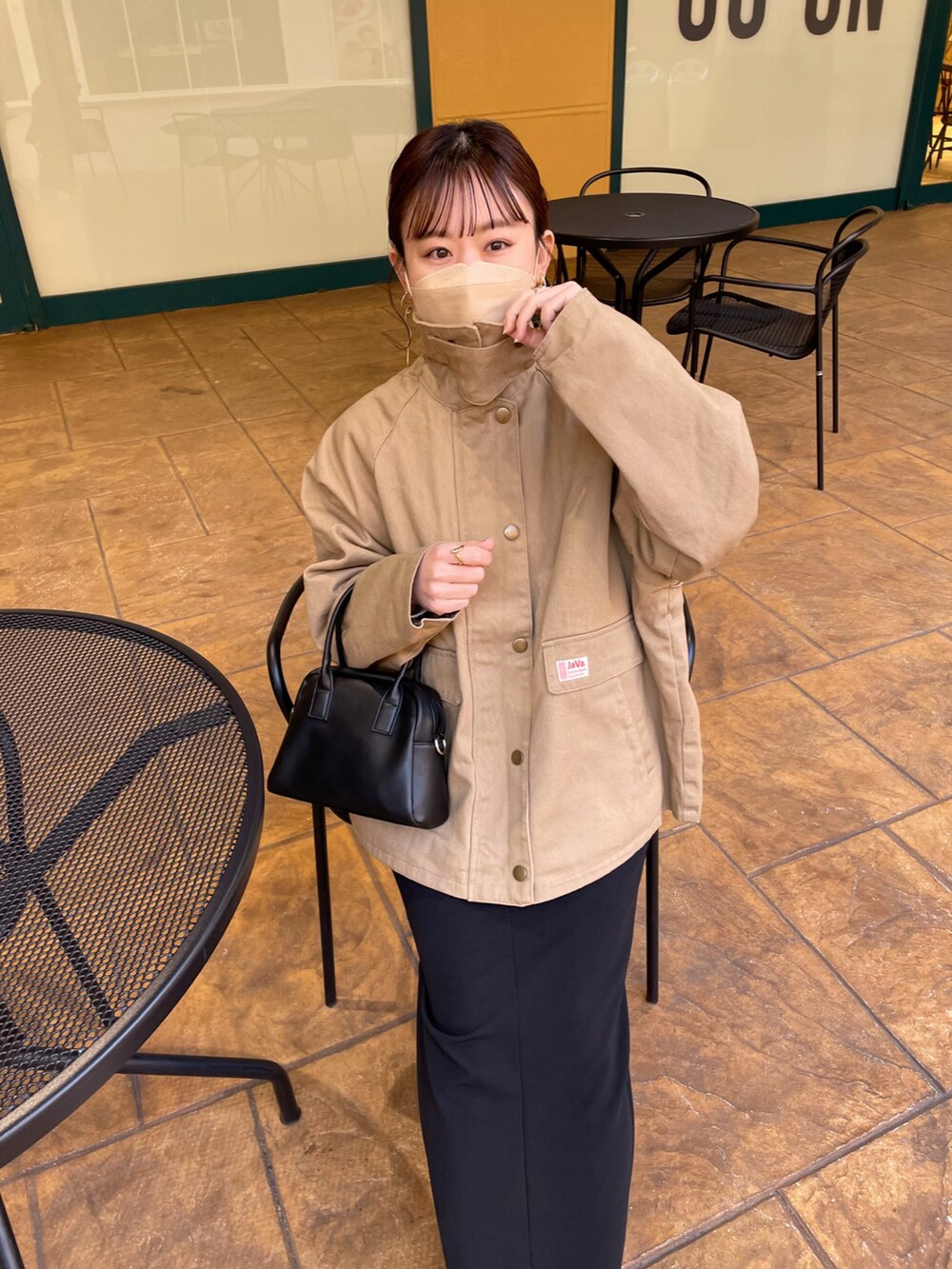ベージュ系のブルゾン、ホワイト系のニット/セーター、ブラック系のスカートを着用したレディースの春コーディネートの5枚目の写真