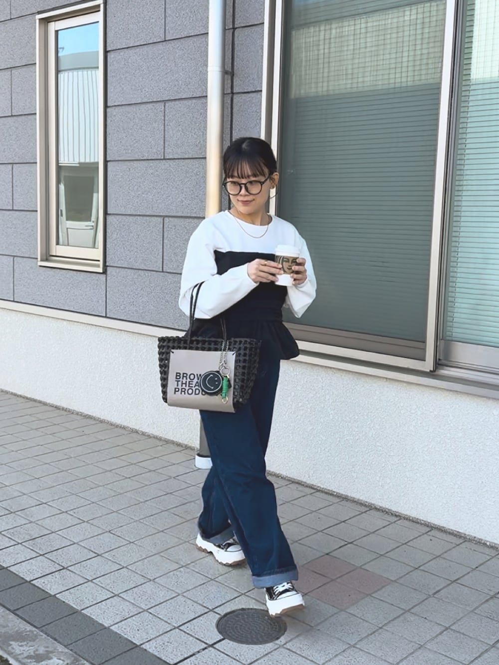 ホワイト系のTシャツ/カットソー、ブラック系のハンドバッグ、ブルー系のパンツを着用したレディースの春コーディネートの3枚目の写真