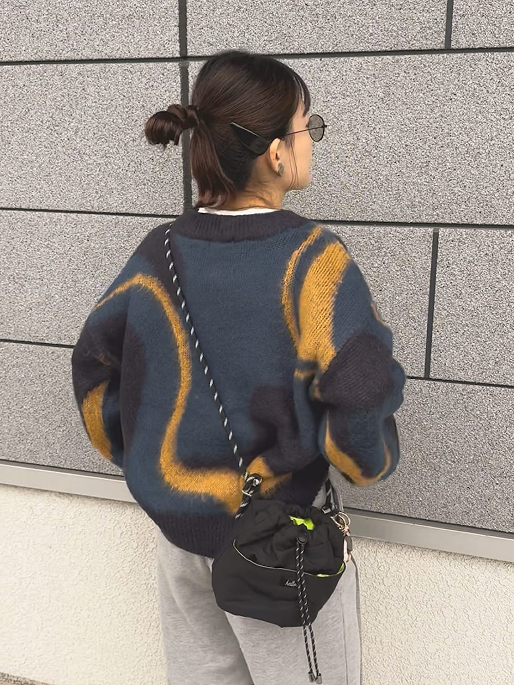 グレー系のスウェットパンツ、ブルー系のニット/セーター、ホワイト系のスニーカーを着用したレディースの冬コーディネートの2枚目の写真