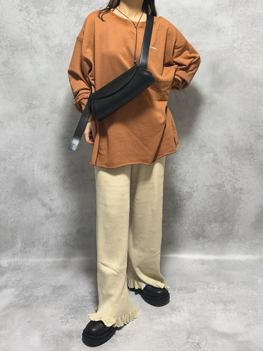 ブラウン系のスウェット、ホワイト系のその他パンツ、ブラック系のショルダーバッグを着用したレディースの秋コーディネートの3枚目の写真