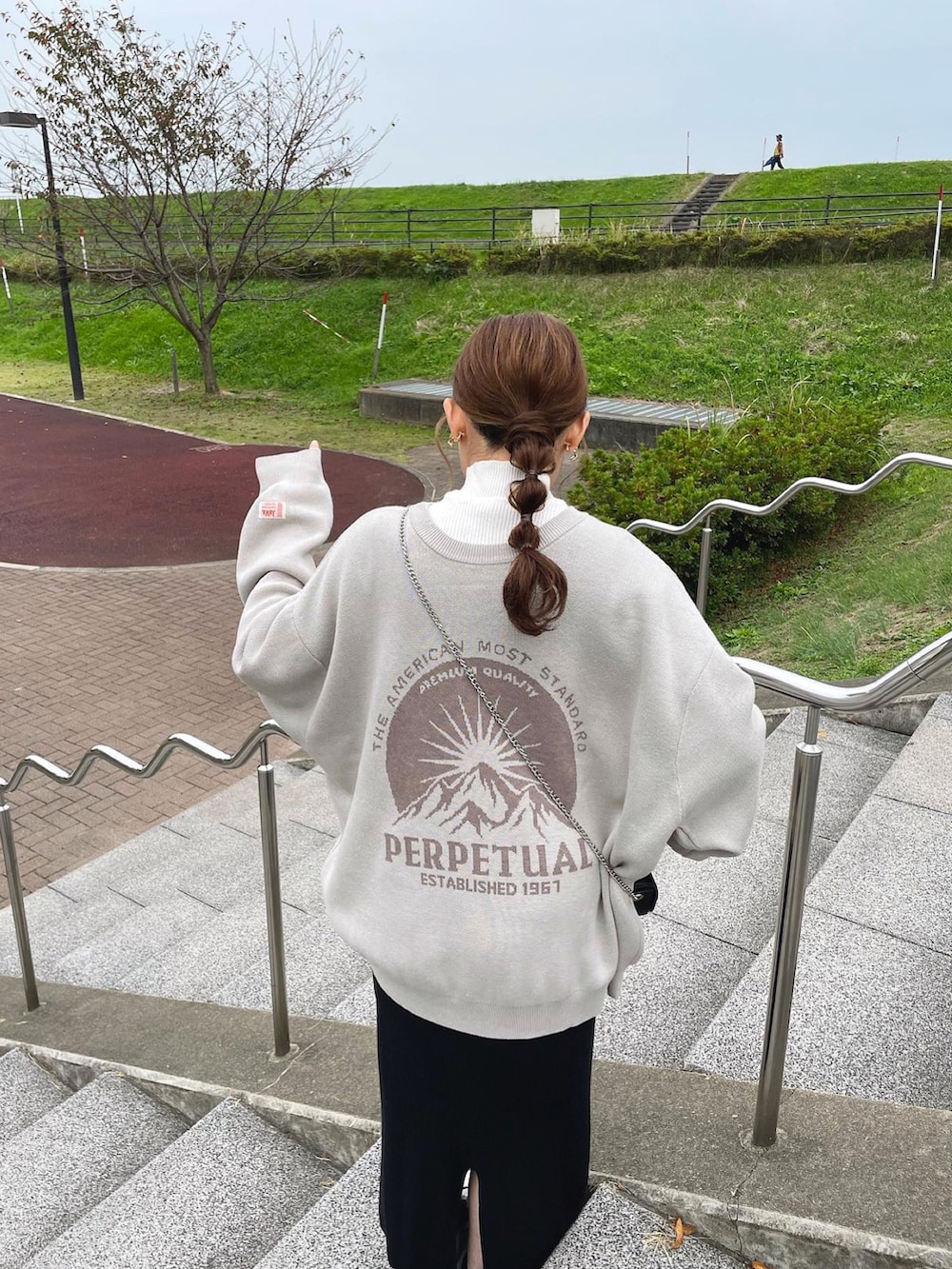 ベージュ系のニット/セーター、ホワイト系のニット/セーター、ブラック系のショルダーバッグを着用したレディースの冬コーディネートの2枚目の写真