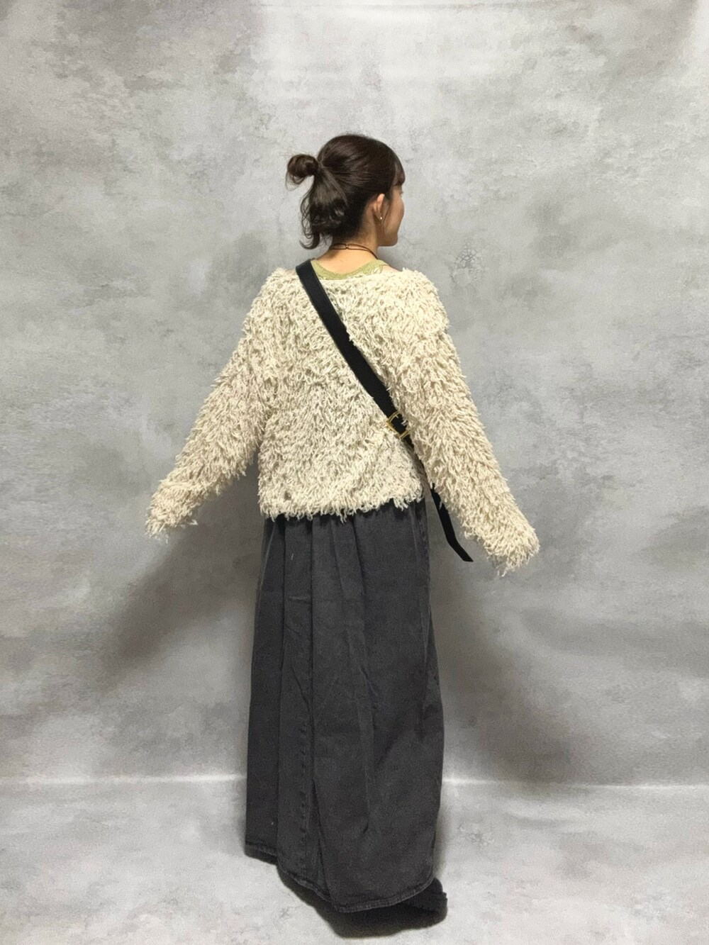 グリーン系のタンクトップ、ブラック系のワンピース/ドレス、ホワイト系のカーディガン/ボレロを着用したレディースの秋コーディネートの2枚目の写真