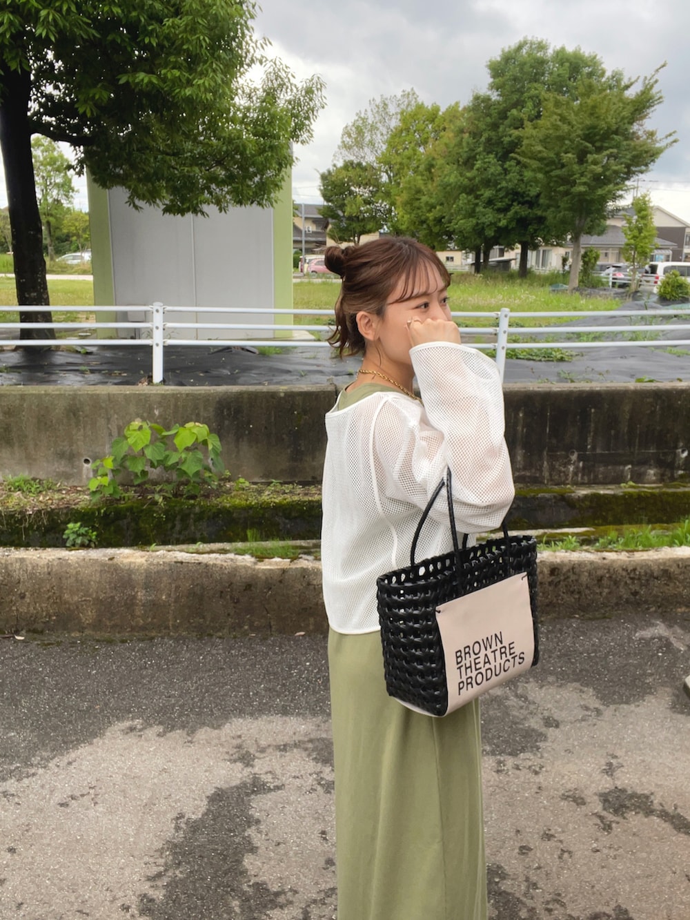 グリーン系のワンピース/ドレス、ブラック系のハンドバッグ、ホワイト系のサンダルを着用したレディースの夏コーディネートの4枚目の写真