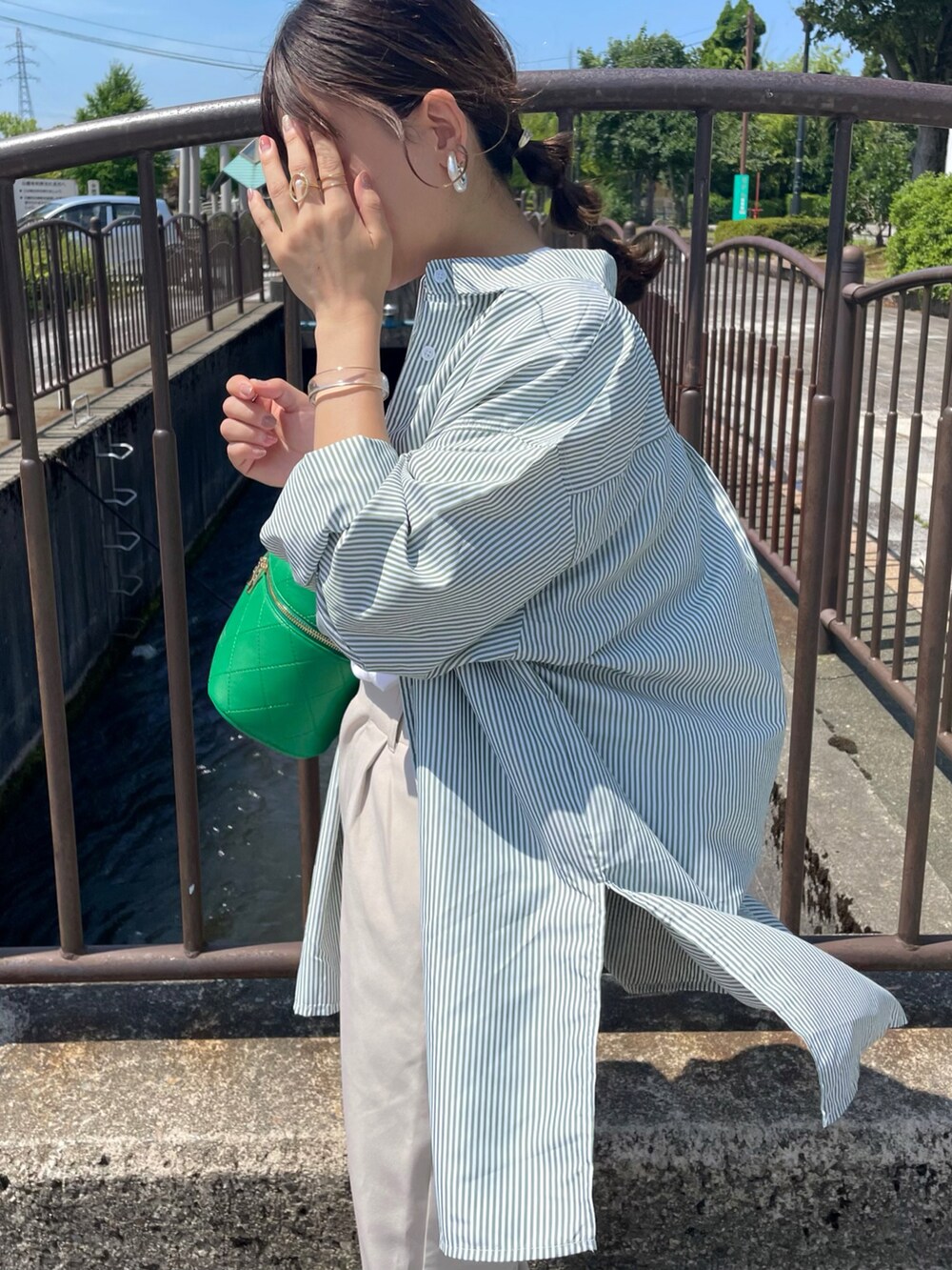 グリーン系のショルダーバッグ、グリーン系のシャツ/ブラウス、ホワイト系のTシャツ/カットソーを着用したレディースの夏コーディネートの4枚目の写真
