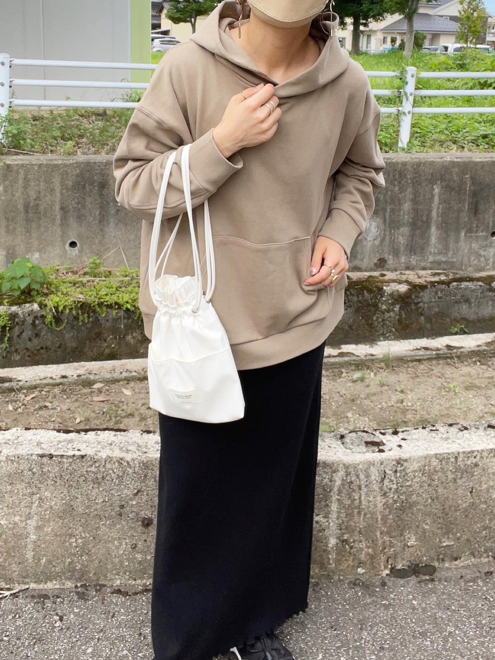 ベージュ系のパーカー、ブラック系のワンピース、ホワイト系のショルダーバッグを着用したレディースの夏コーディネートの3枚目の写真