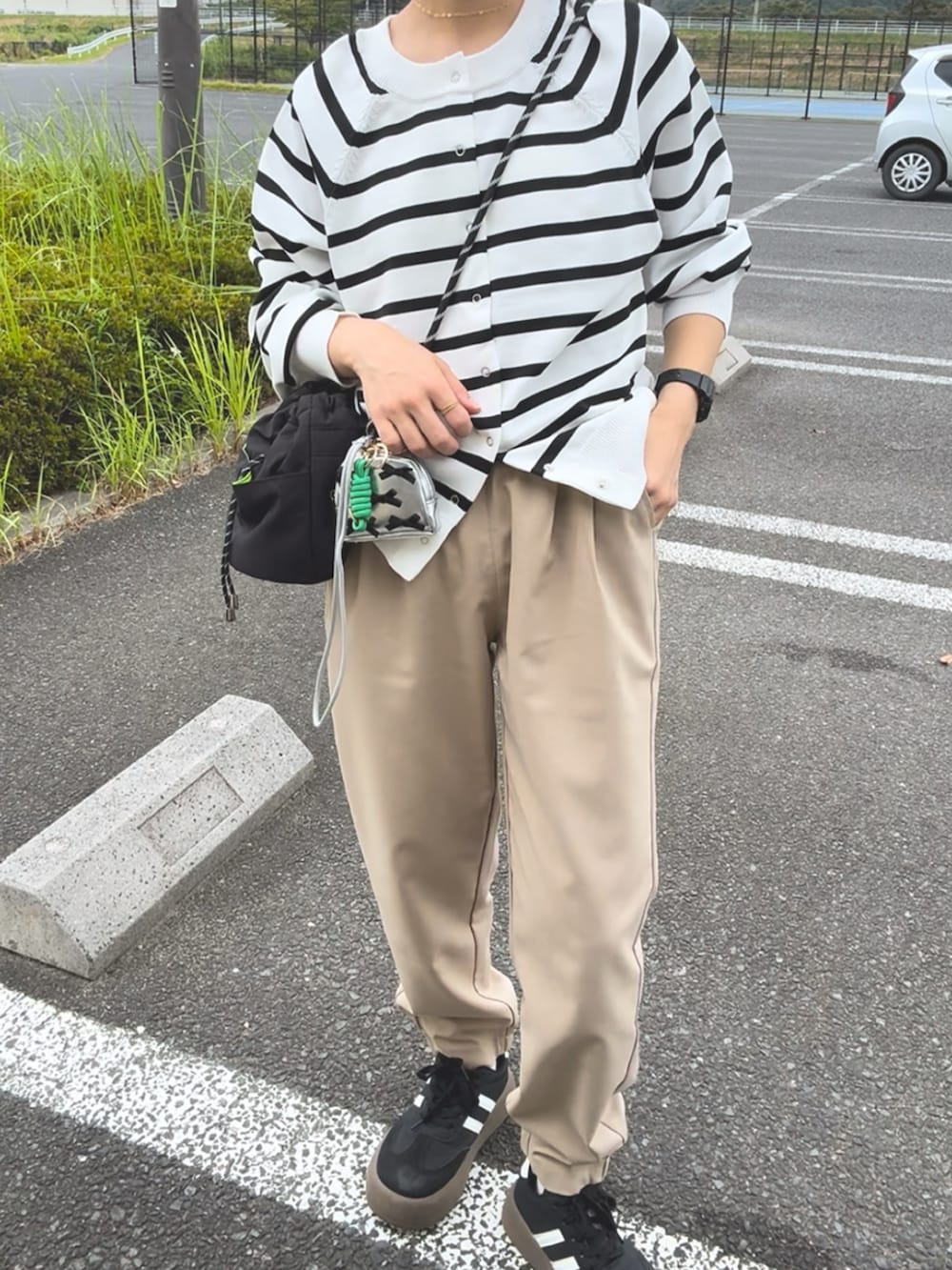 ベージュ系のその他パンツ、ホワイト系のトップス、ブラック系のスニーカーを着用したレディースの秋コーディネートの2枚目の写真