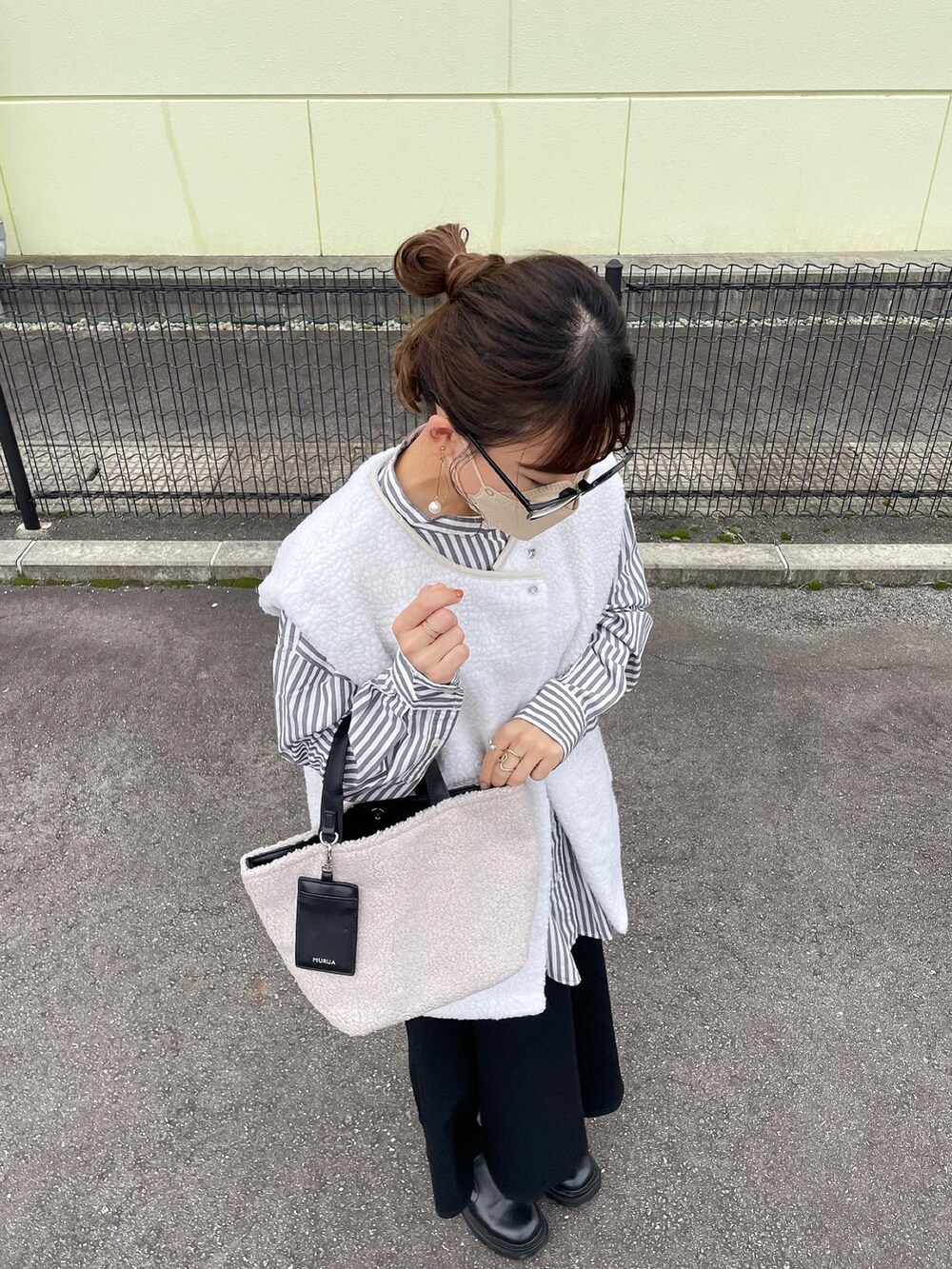 グレー系のトートバッグ、グレー系のシャツ/ブラウス、ホワイト系のベストを着用したレディースの秋コーディネートの2枚目の写真