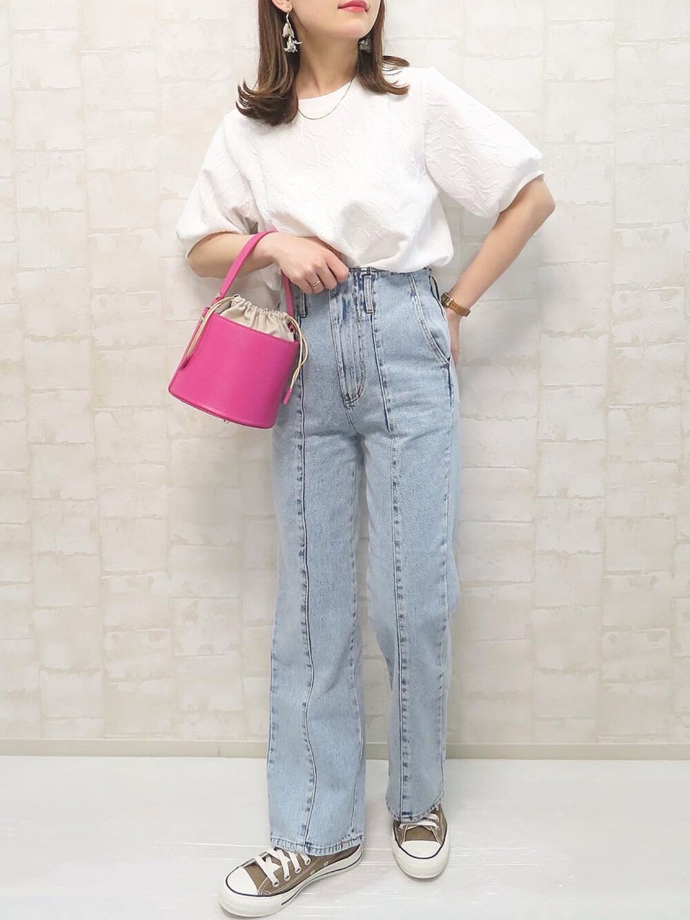 ホワイト系のTシャツ/カットソー、ブルー系のデニムパンツ、ピンク系のショルダーバッグを着用したレディースの春コーディネートの2枚目の写真