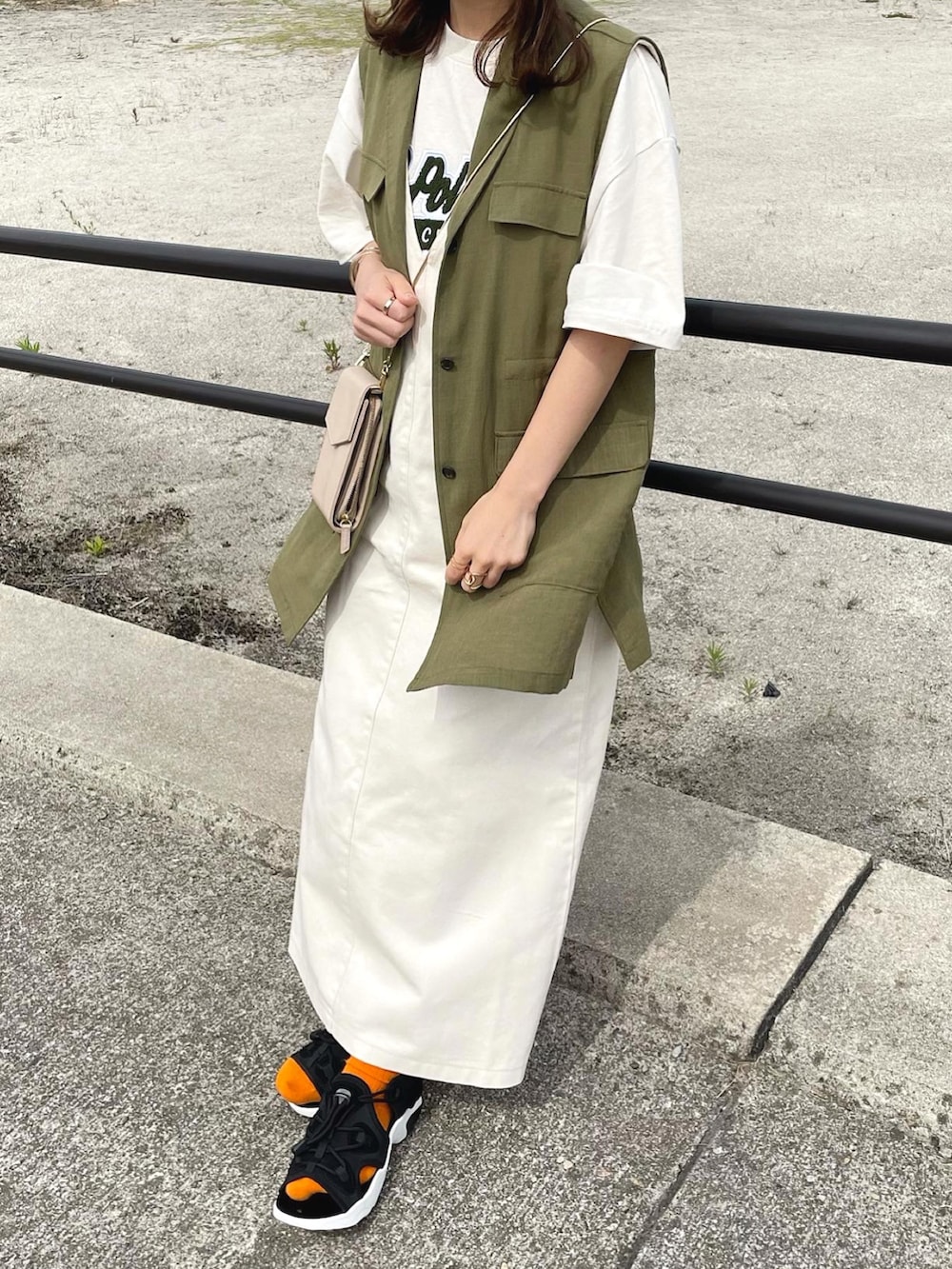 ベージュ系のTシャツ/カットソー、ホワイト系のジャンパースカート、グリーン系のベストを着用したレディースの夏コーディネートの4枚目の写真