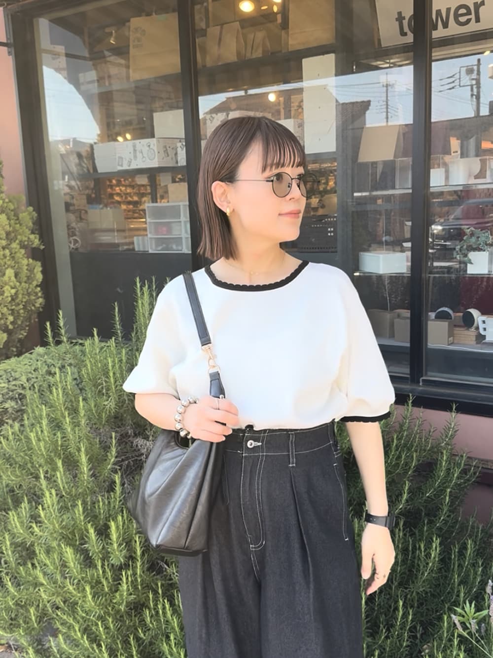 ホワイト系のTシャツ/カットソー、ブラック系のデニムパンツ、ブラック系のバッグを着用したレディースの夏コーディネートの4枚目の写真