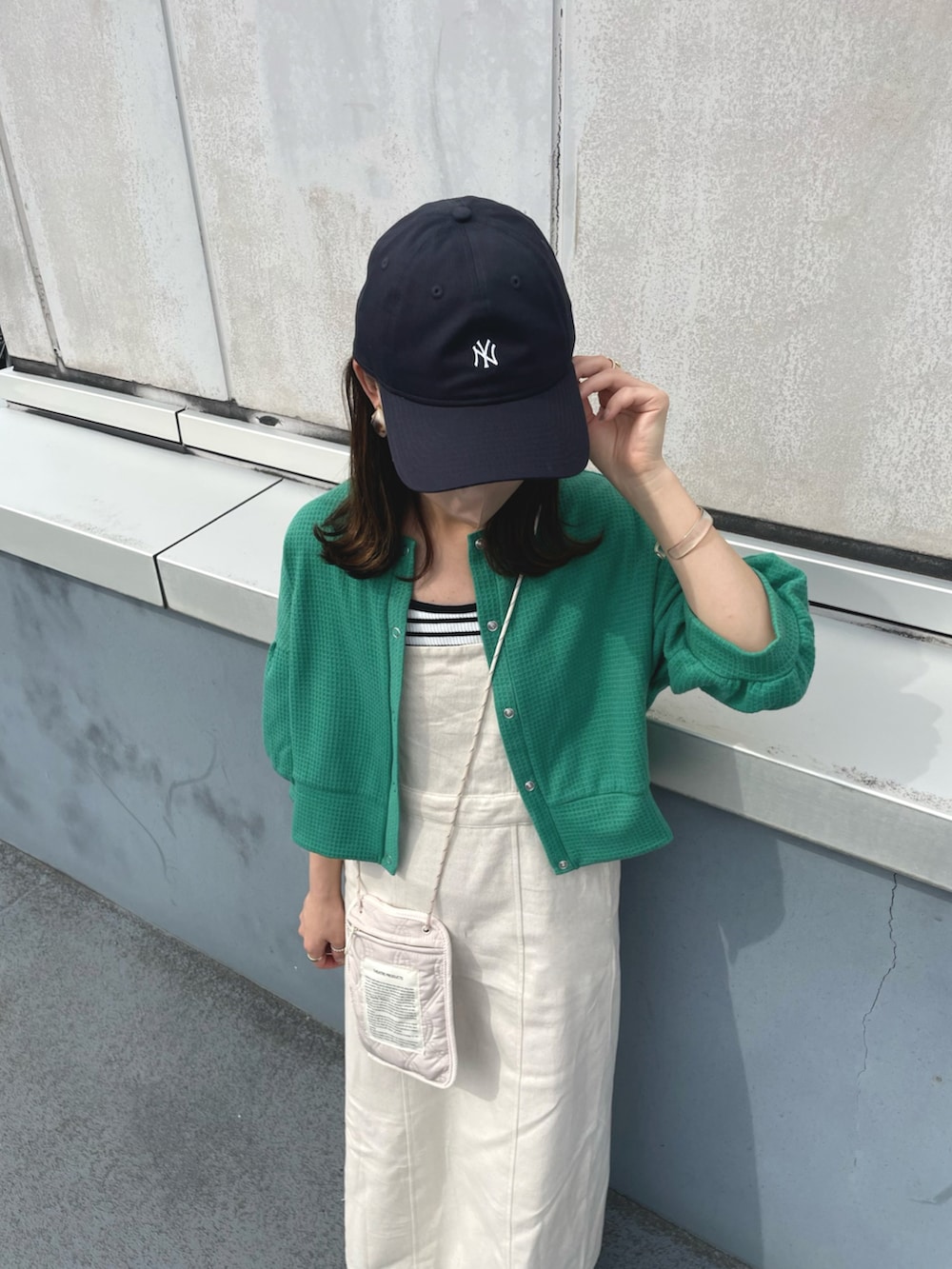 グリーン系のカーディガン/ボレロ、ホワイト系のワンピース、ブラック系のキャミソールを着用したレディースの夏コーディネートの3枚目の写真