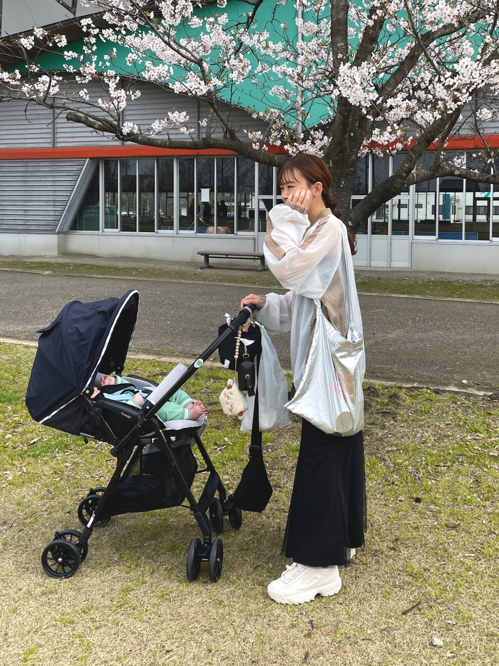 ホワイト系のTシャツ/カットソー、ブラック系のスカート、シルバー系のトートバッグを着用したレディースの春コーディネートの2枚目の写真