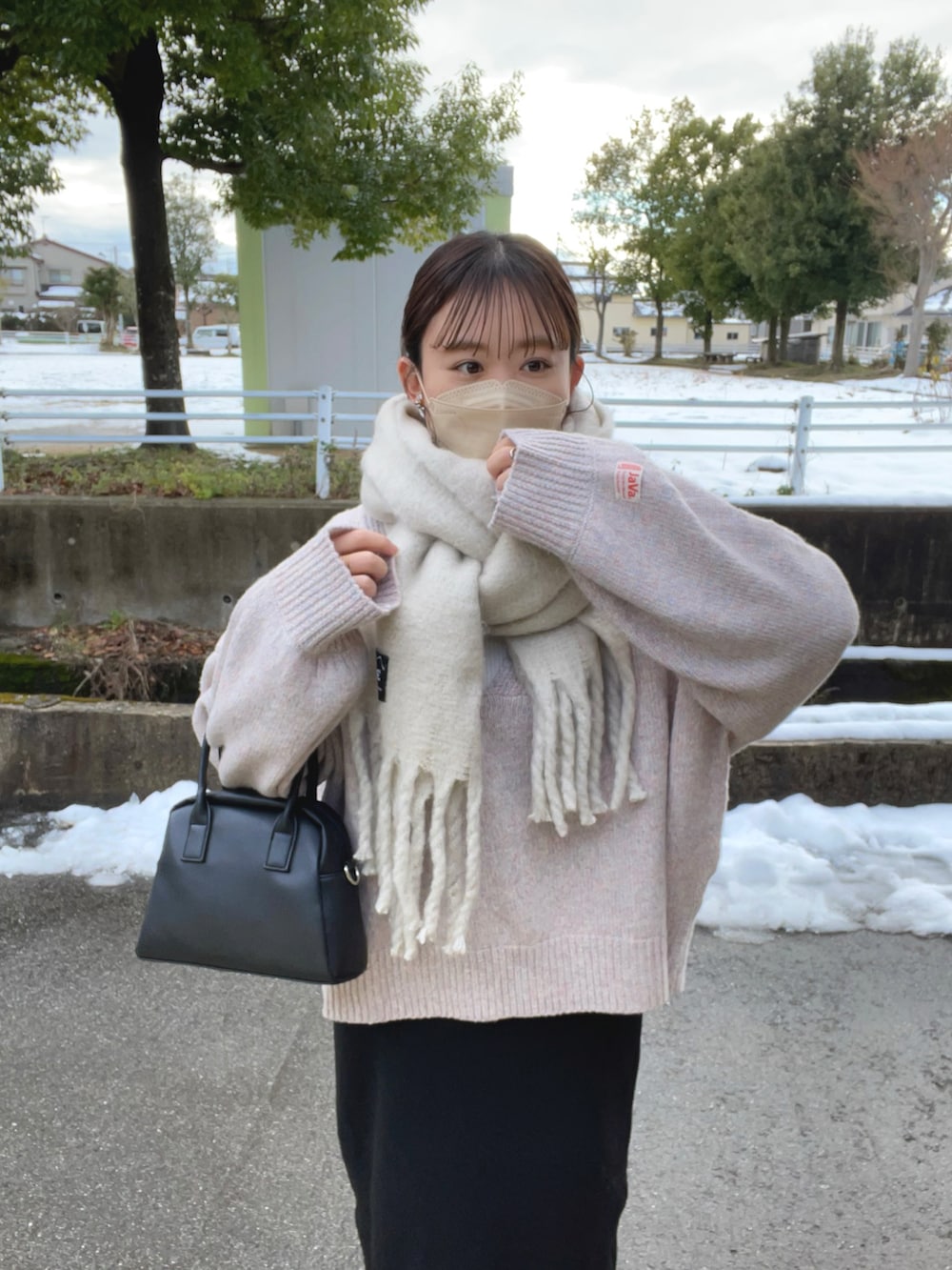 ピンク系のニット/セーター、ホワイト系のニット/セーター、ブラック系のスカートを着用したレディースの冬コーディネートの5枚目の写真