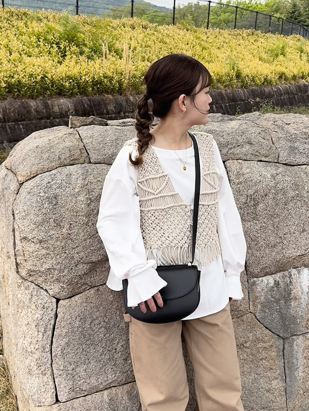 ホワイト系のTシャツ/カットソー、その他のベスト、ブラック系のショルダーバッグを着用したレディースの春コーディネートの2枚目の写真