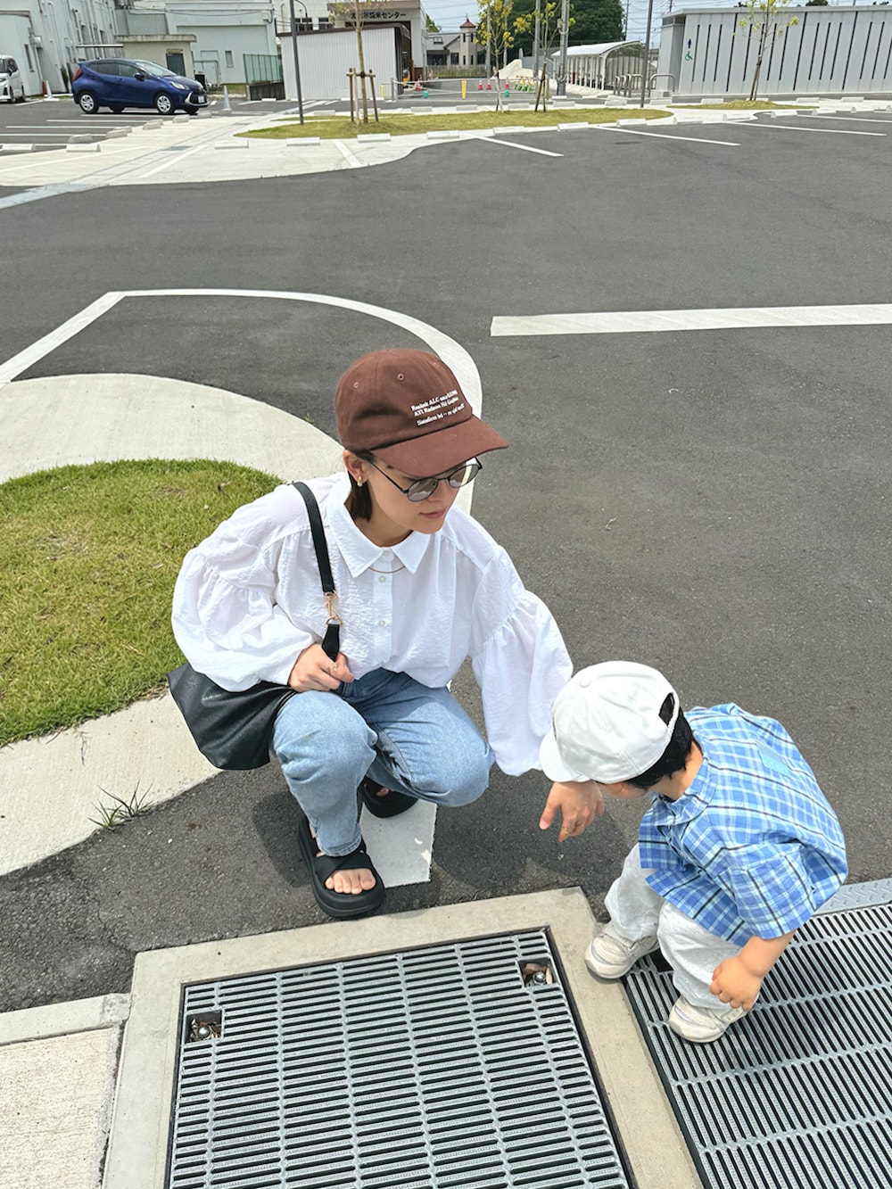 ホワイト系のシャツ/ブラウス、ブルー系のデニムパンツ、ブラック系のバッグを着用したレディースの秋コーディネートの4枚目の写真
