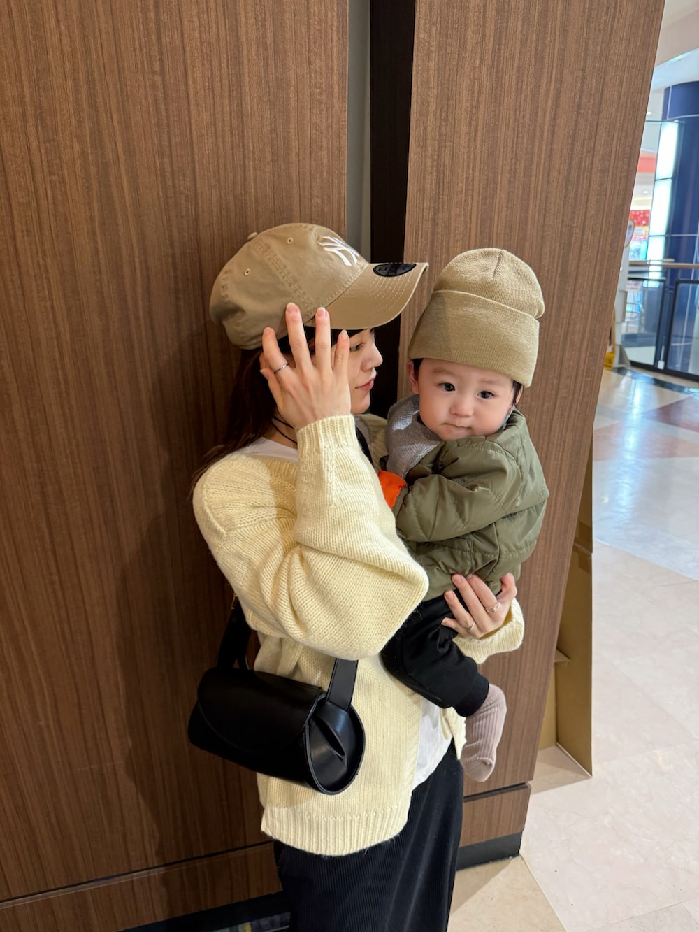 ホワイト系のカーディガン/ボレロ、ブラック系のスカート、ブラック系のショルダーバッグを着用したレディースの冬コーディネートの5枚目の写真