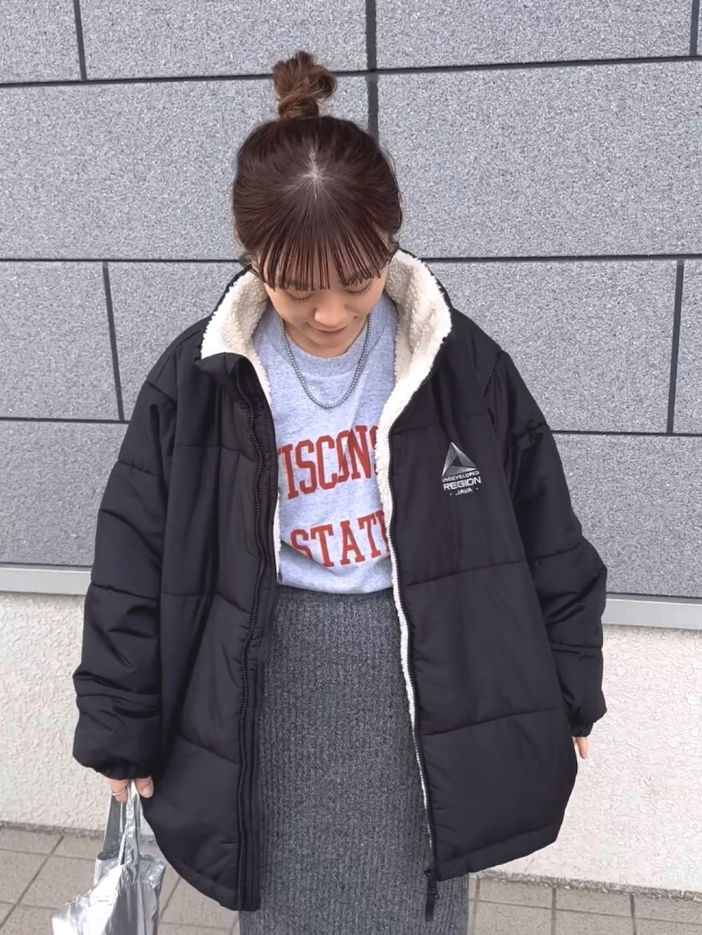 ブラック系のブルゾン、グレー系のTシャツ/カットソー、グレー系のスカートを着用したレディースの冬コーディネートの3枚目の写真