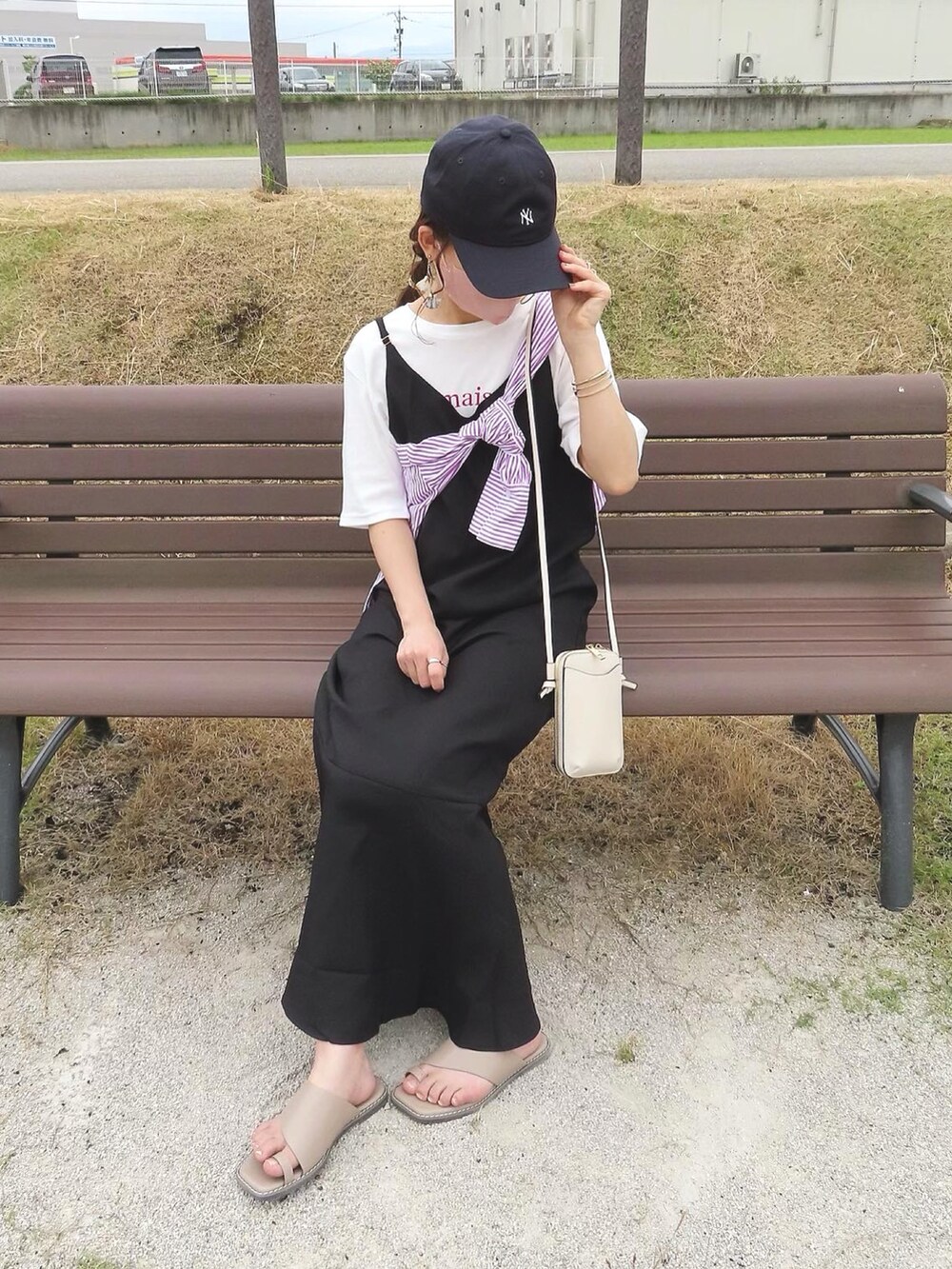 ピンク系のシャツ/ブラウス、ブラック系のジャンパースカート、ホワイト系のバッグを着用したレディースの夏コーディネートの2枚目の写真