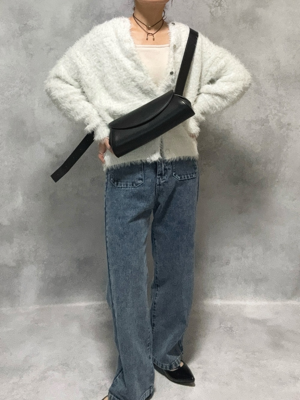 ホワイト系のニット/セーター、ブルー系のデニムパンツ、ブラック系のショルダーバッグを着用したレディースの秋コーディネートの3枚目の写真