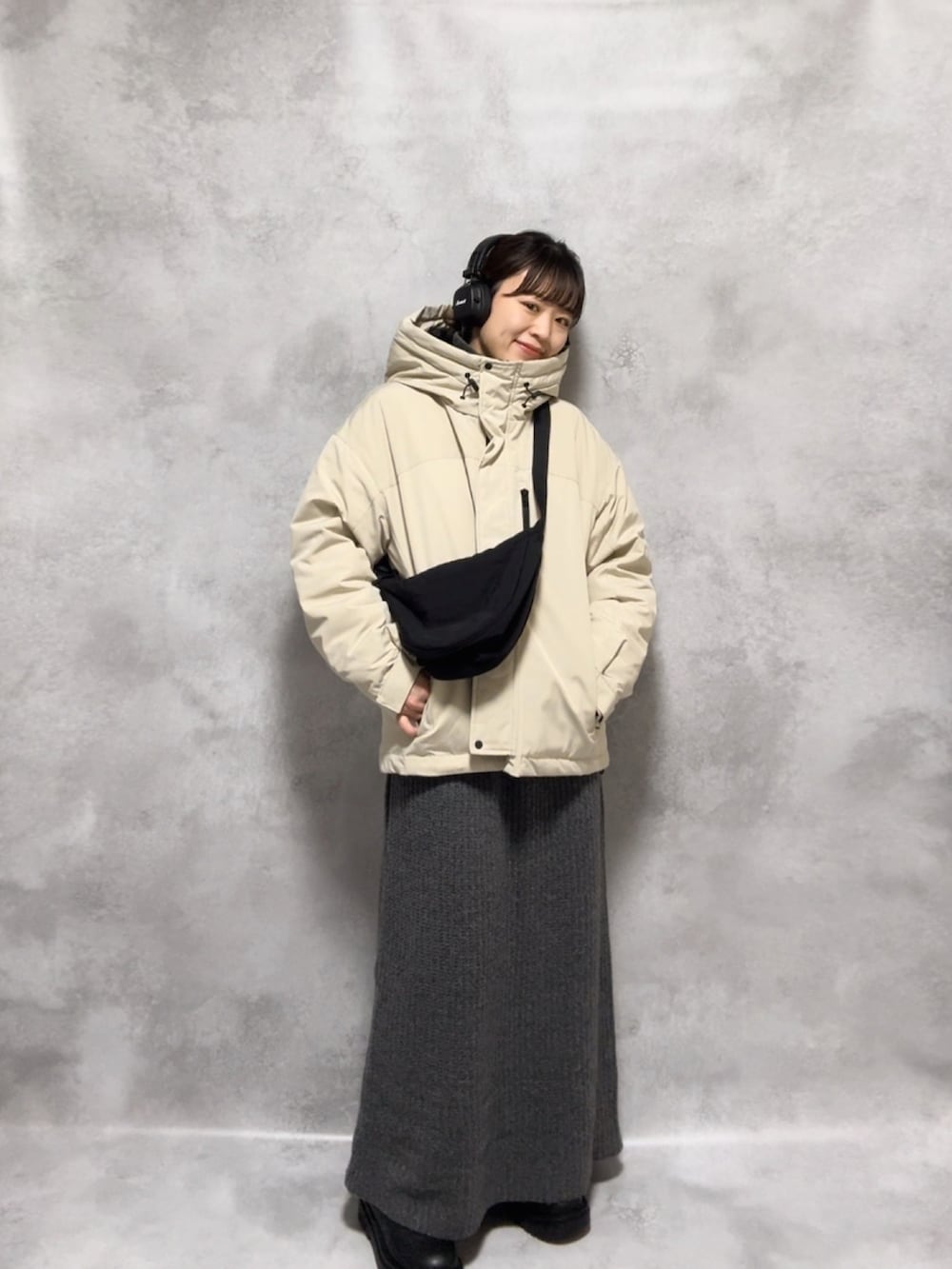 ベージュ系のダウンジャケット/コート、グレー系のワンピース、ブラック系のショルダーバッグを着用したレディースの秋コーディネートの2枚目の写真