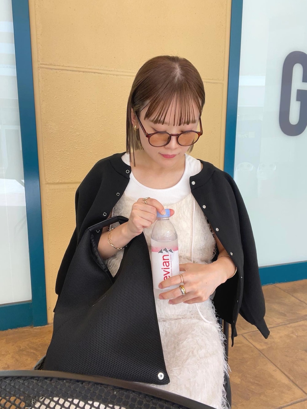 ブラック系のカーディガン/ボレロ、ホワイト系のワンピース、ブラック系のトートバッグを着用したレディースの秋コーディネートの3枚目の写真