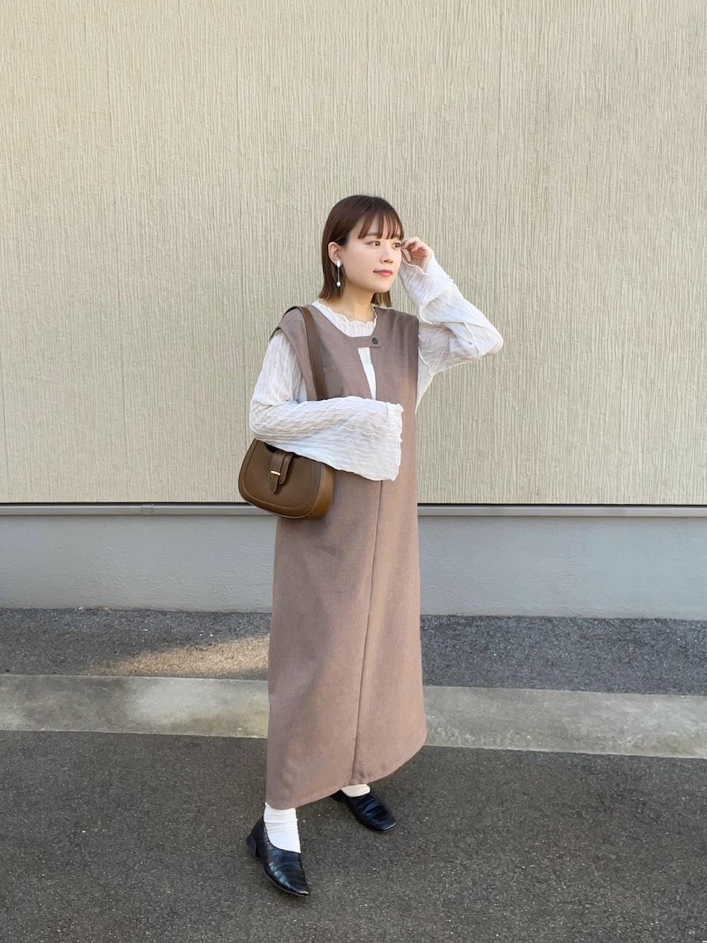 ホワイト系のトップス、ブラウン系のワンピース/ドレス、ブラウン系のバッグを着用したレディースの夏コーディネートの2枚目の写真