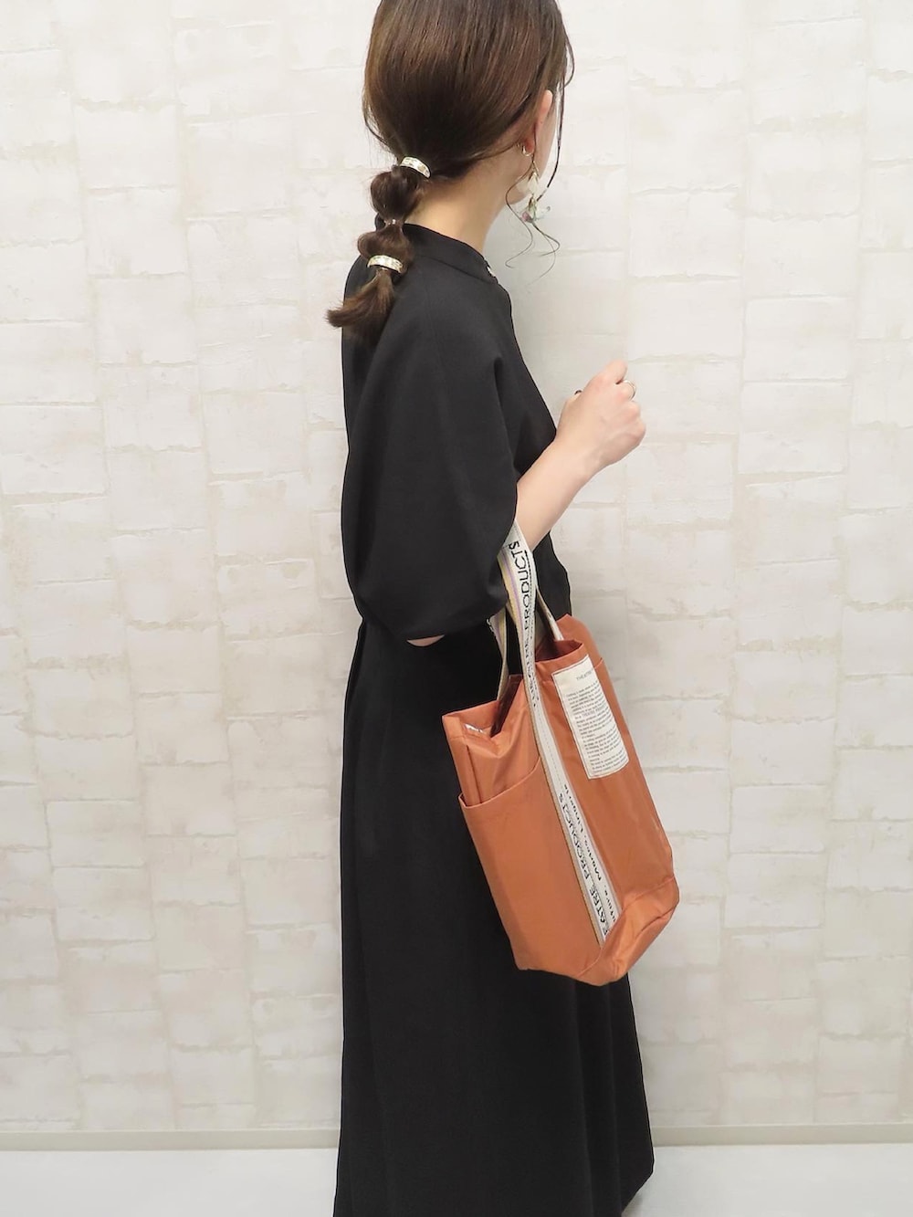 ブラック系のワンピース、オレンジ系のトートバッグ、オレンジ系のソックス/靴下を着用したレディースの夏コーディネートの3枚目の写真