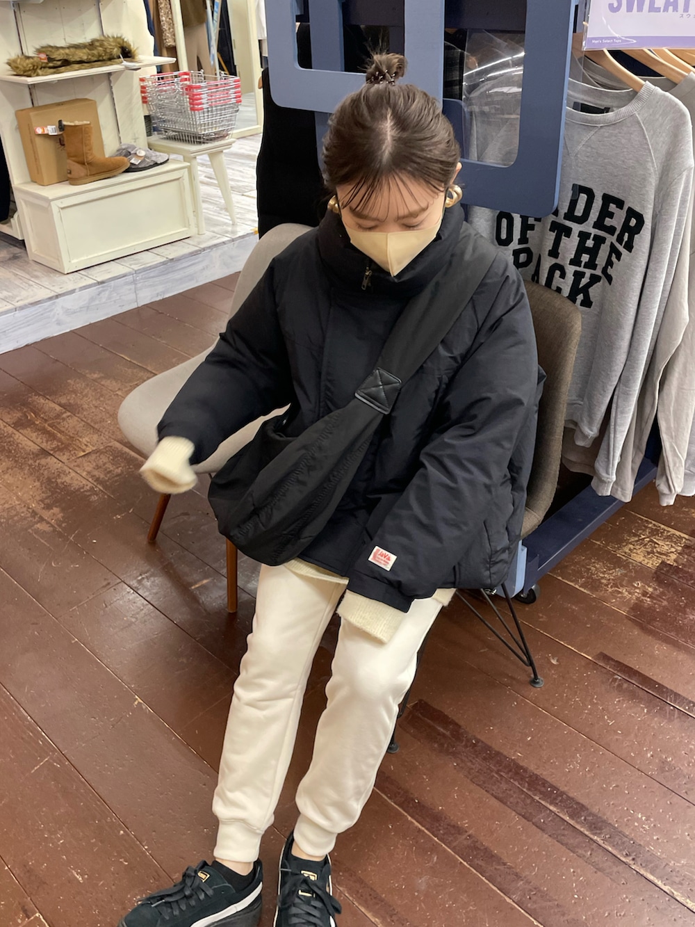 ホワイト系のパンツ、ブラック系のダウンジャケット/コート、ブラック系のショルダーバッグを着用したレディースの冬コーディネートの5枚目の写真