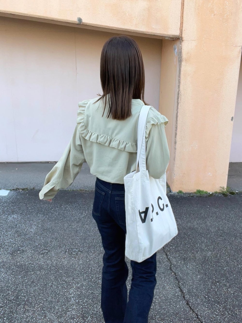 グリーン系のシャツ/ブラウス、ブルー系のデニムパンツ、ホワイト系のトートバッグを着用したレディースの冬コーディネートの3枚目の写真
