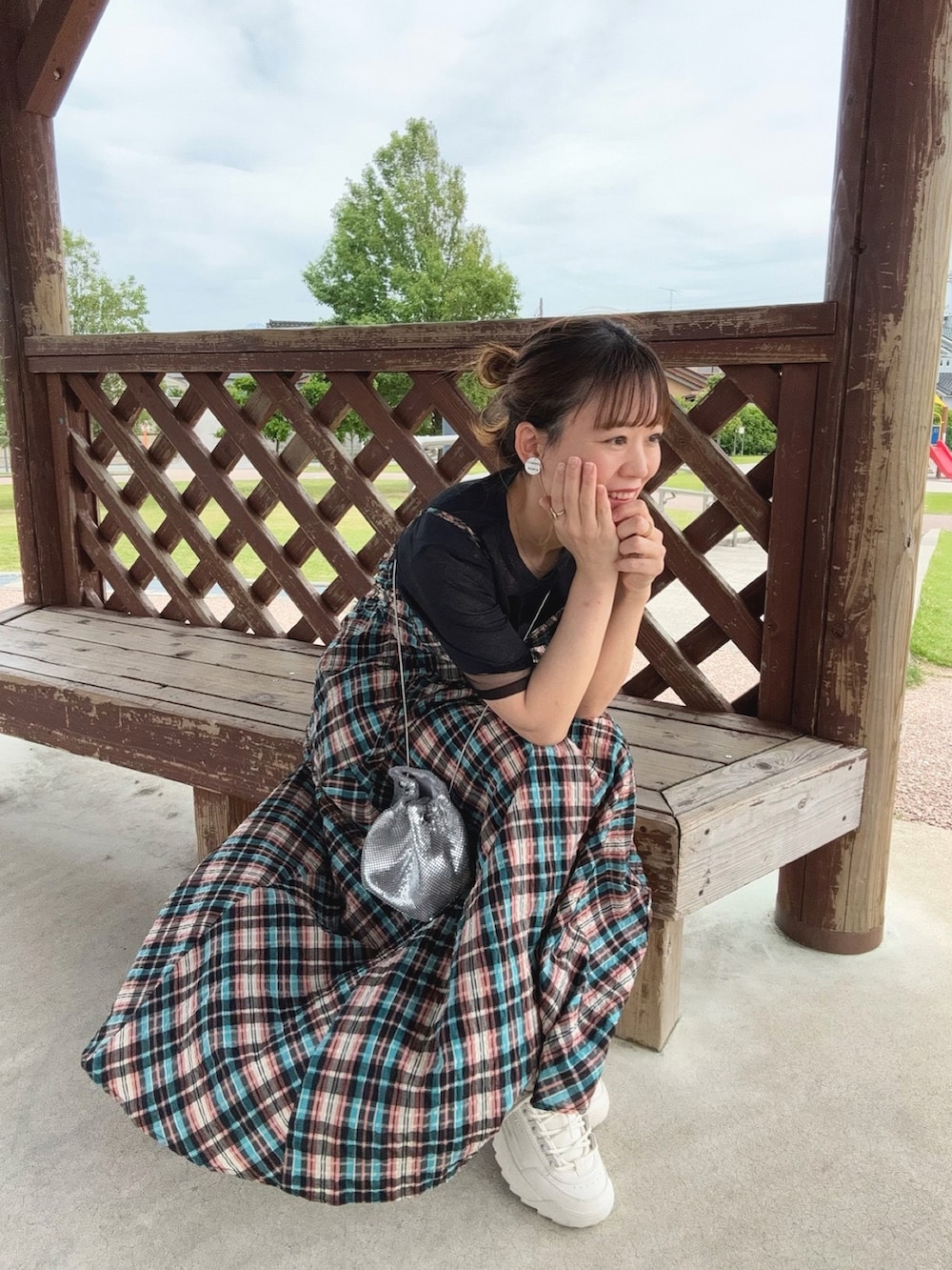 オレンジ系のワンピース、ブラック系のTシャツ/カットソー、シルバー系のバッグを着用したレディースの春コーディネートの3枚目の写真