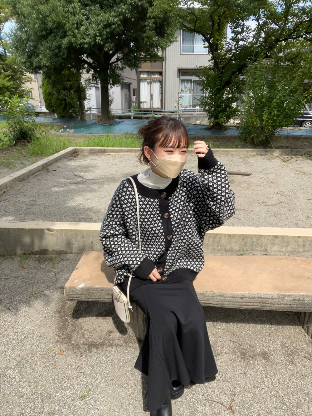 ブラック系のカーディガン/ボレロ、ホワイト系のTシャツ/カットソー、ブラック系のスカートを着用したレディースの秋コーディネートの3枚目の写真